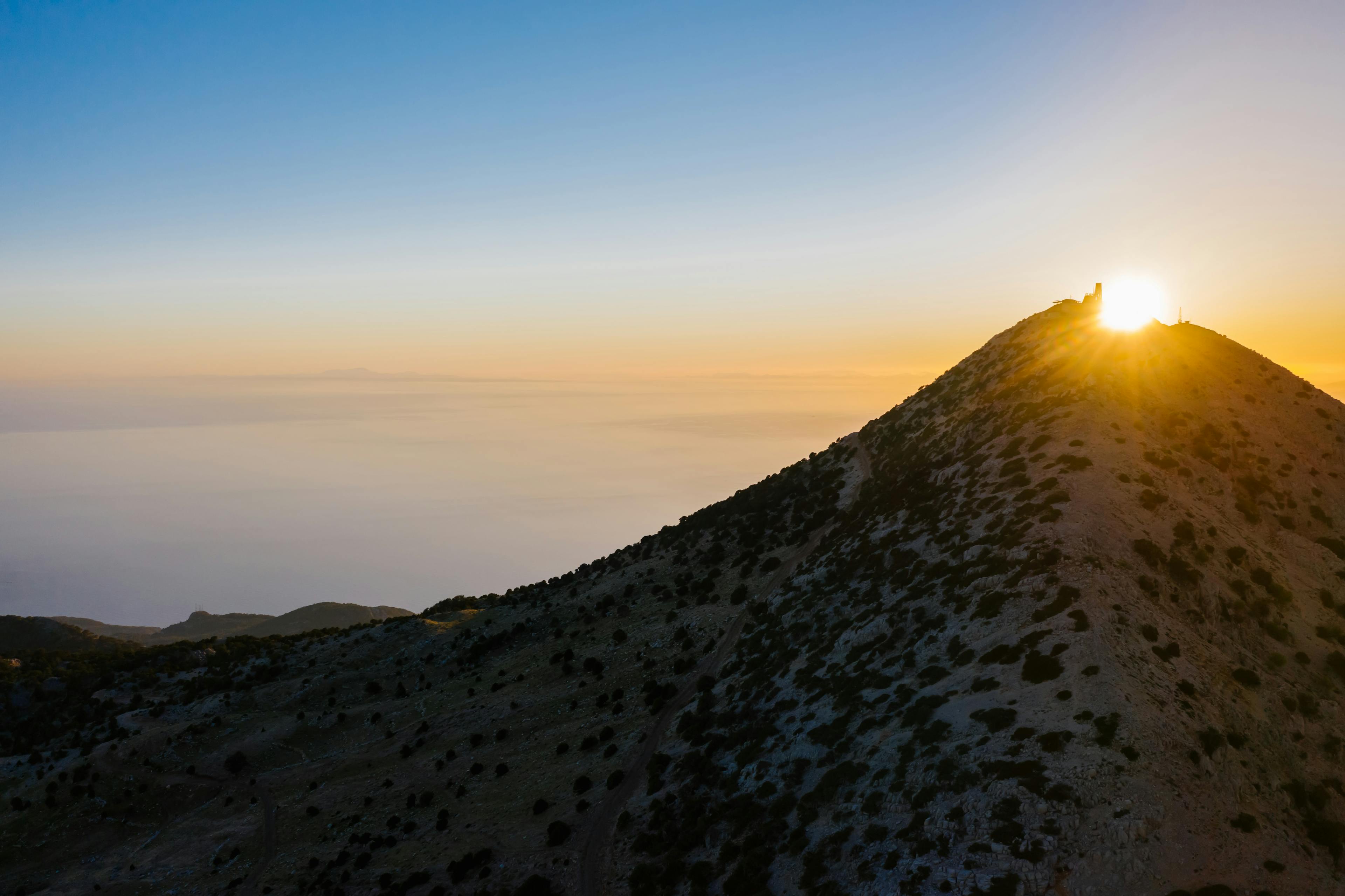 Sunset over a mountain summit representing the public peak and career heights of the 10th house