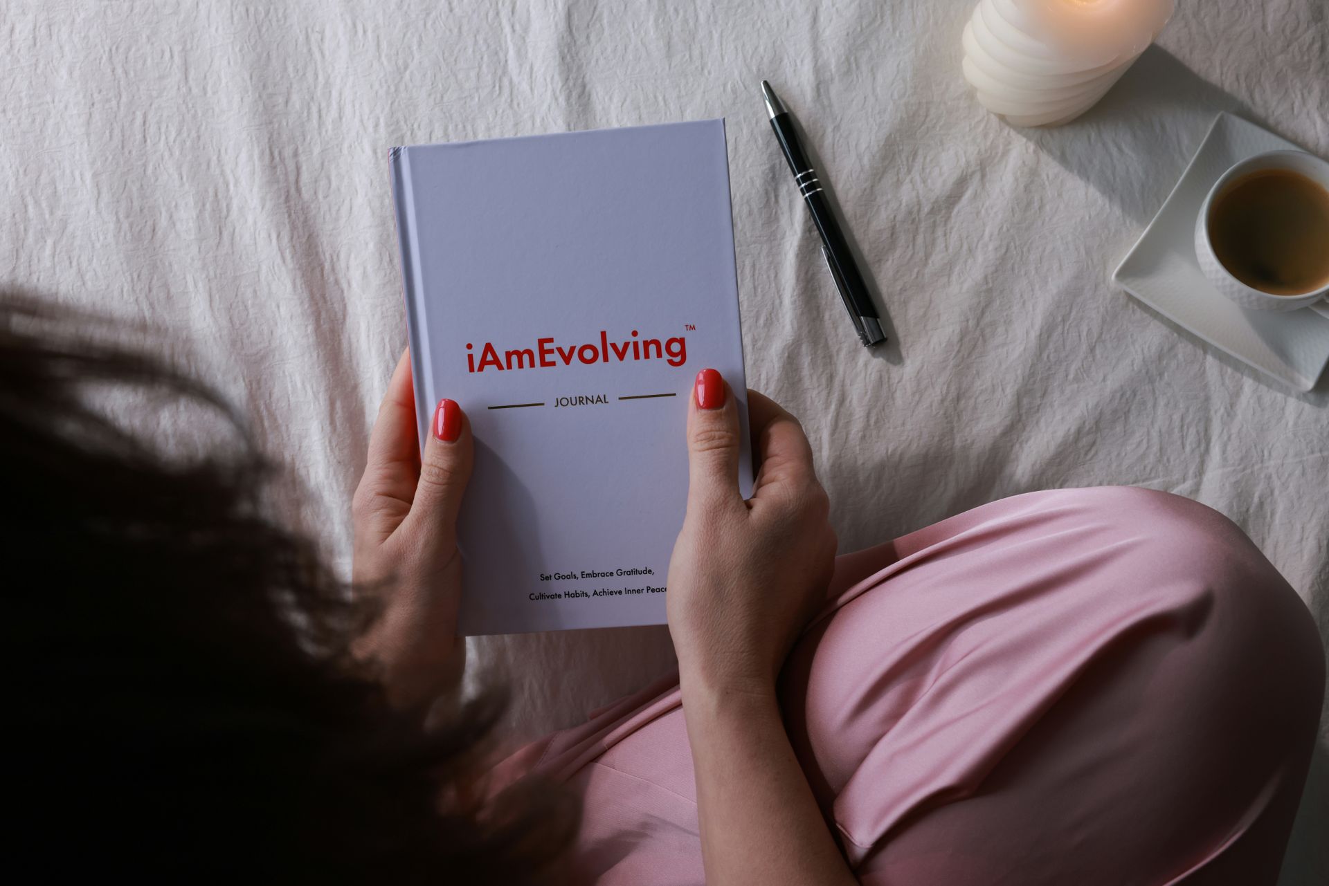A person writing affirmations in a journal by candlelight, illustrating a calm 369 method routine