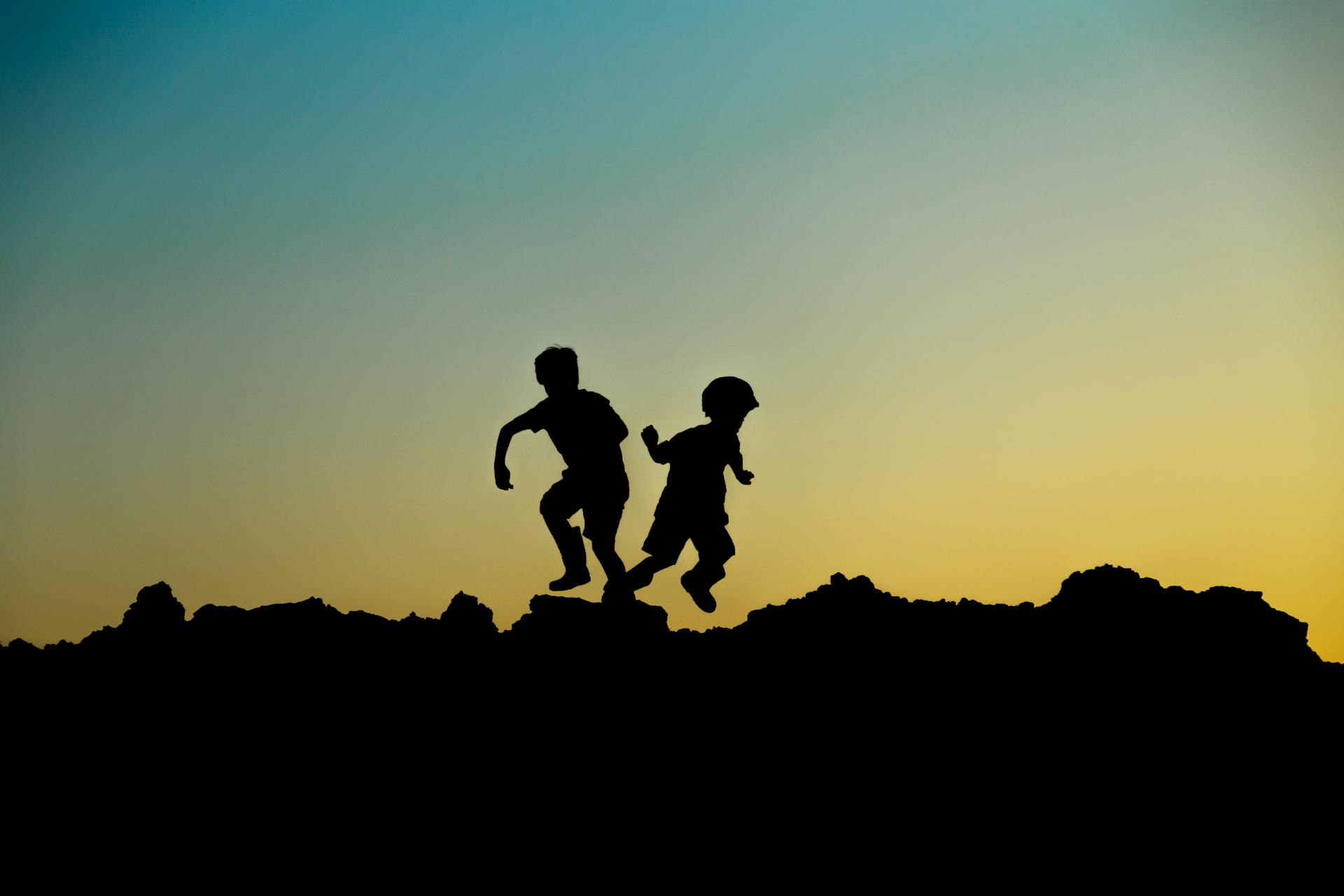 Silhouettes of children playing outdoors at sunset capturing the joyful spirit of the 5th house