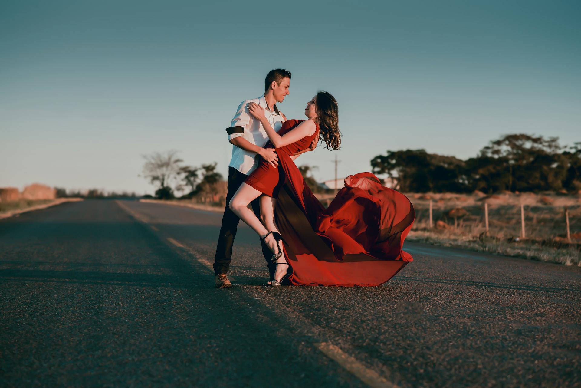 Couple dancing on an empty road at golden sunset symbolizing the 5th house theme of romantic passion