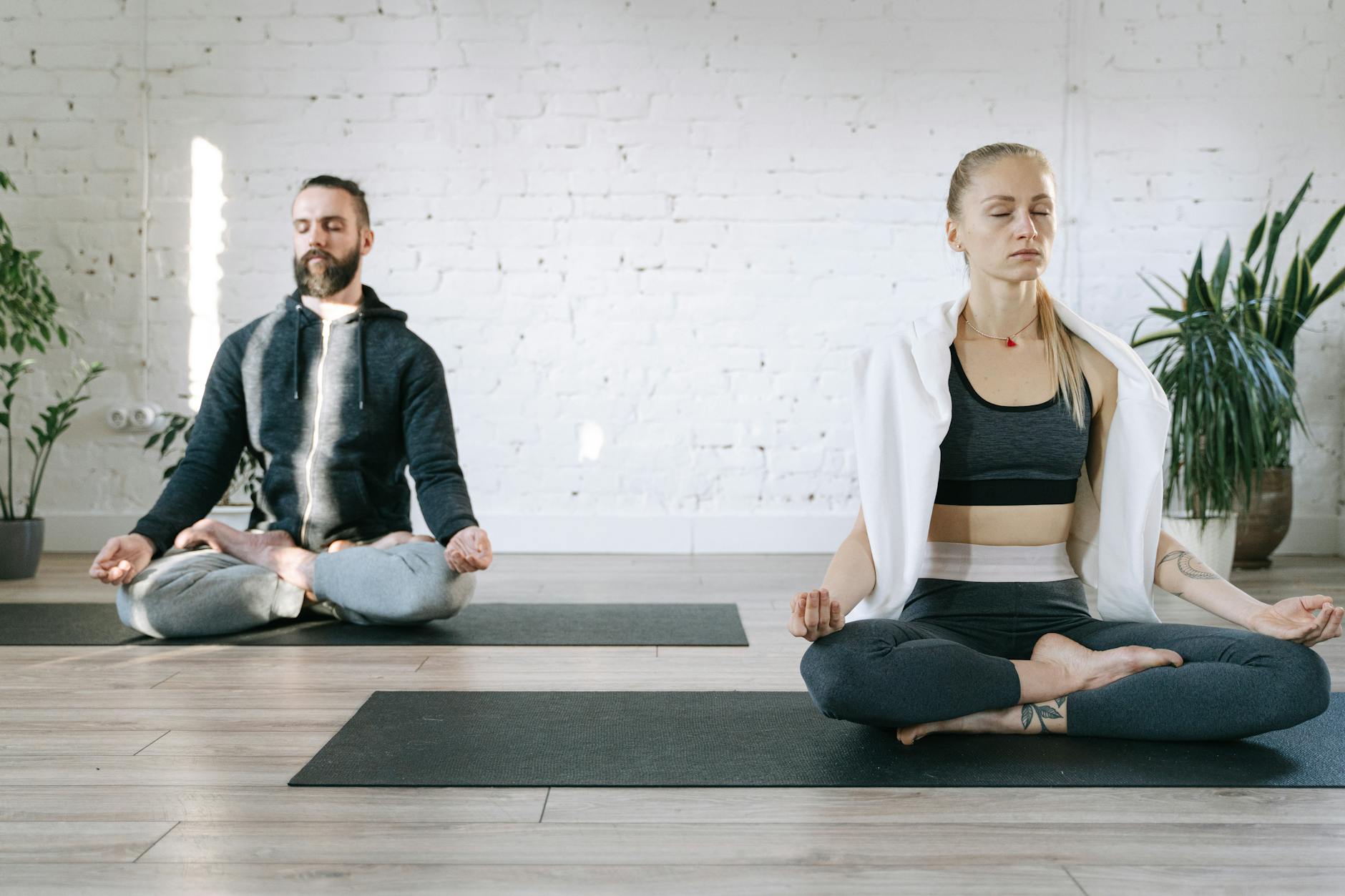 A yoga mat and meditation cushion in a sunlit room representing the body care and routine themes of the 6th house