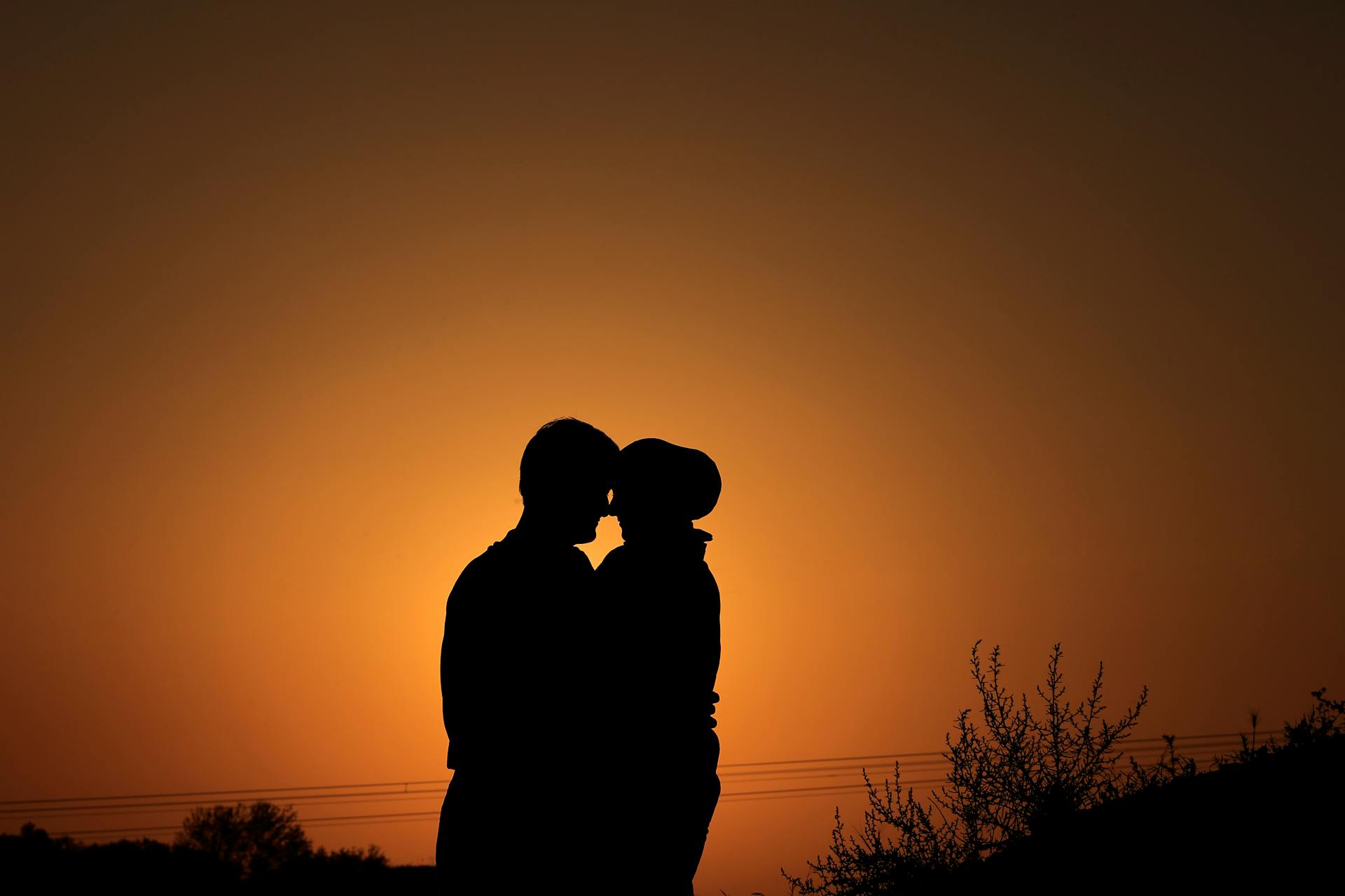 Couple embracing on a pier at sunset representing the lifelong commitment side of the 7th house