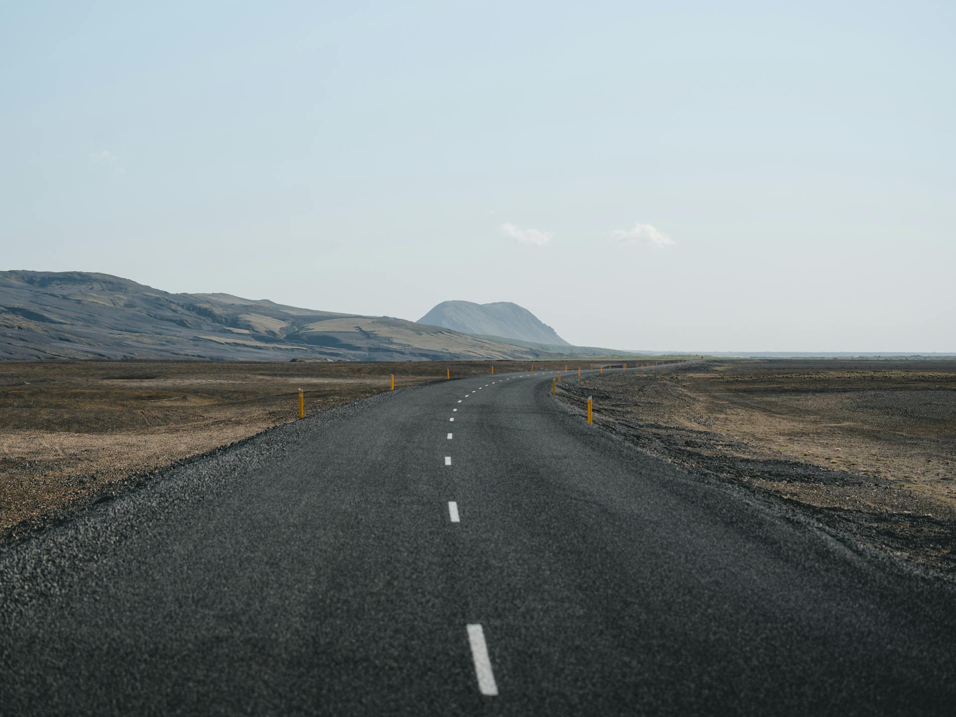 Empty highway stretching toward distant mountains representing the long journeys ruled by the 9th house