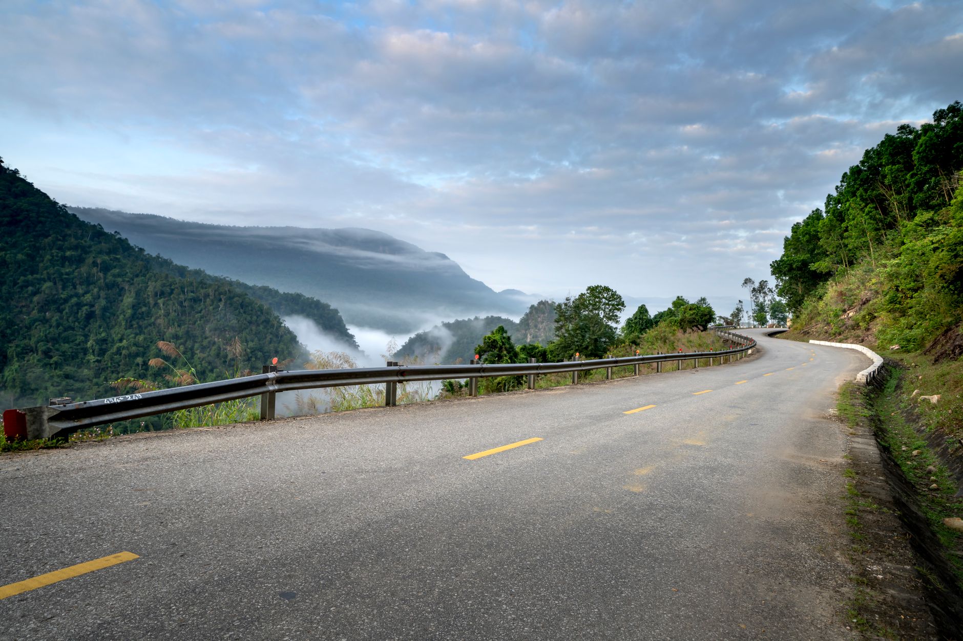 A winding open road leading toward a bright sunrise over distant mountains, representing growth, momentum, and forward movement linked to angel number 333