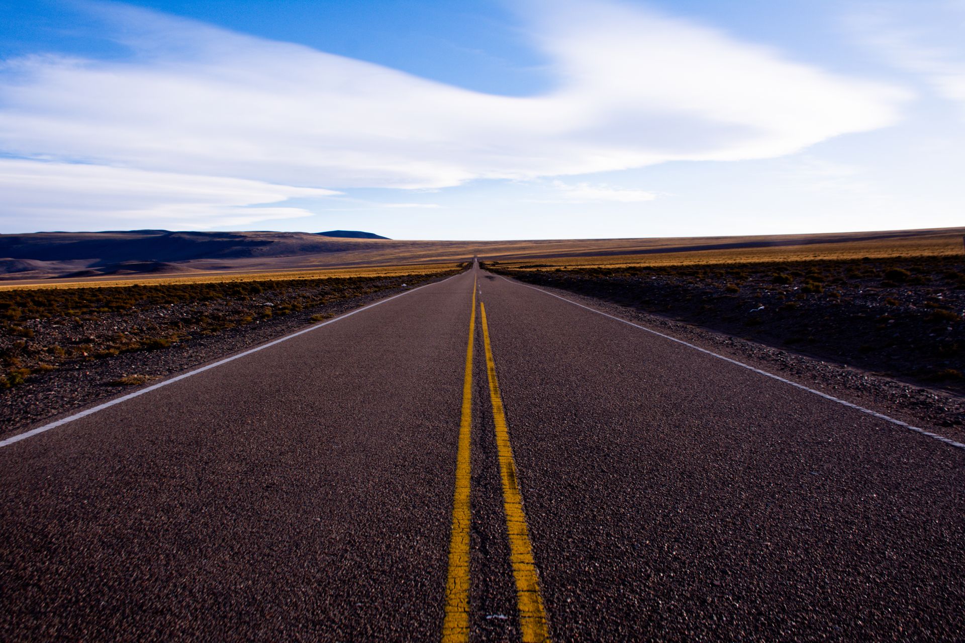 A long open road stretching toward the horizon under a clear sky, representing the new direction and freedom linked to angel number 555