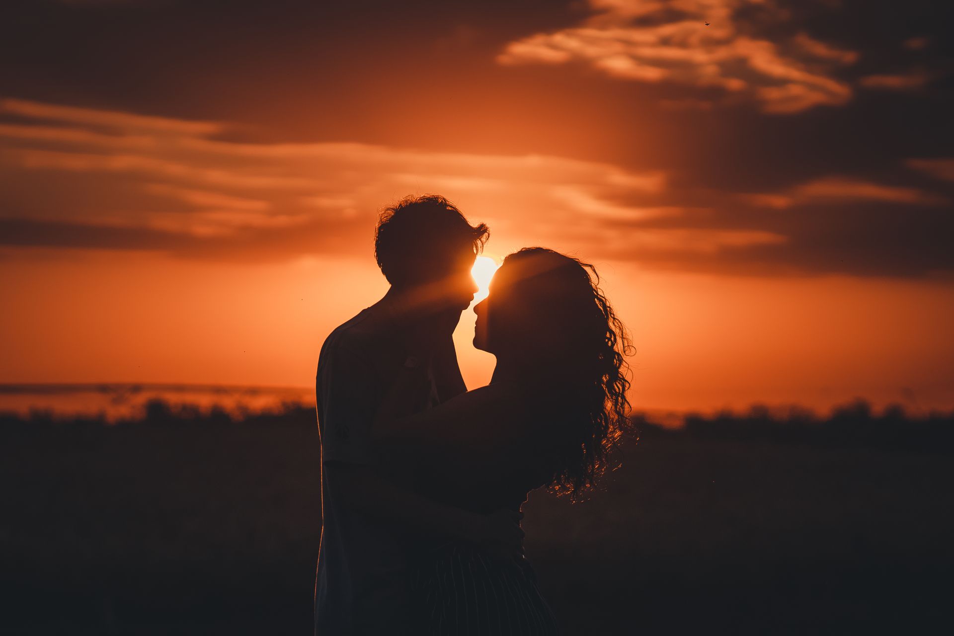 A silhouette of a couple embracing at sunset, representing the balance and trust angel number 666 brings to love and relationships