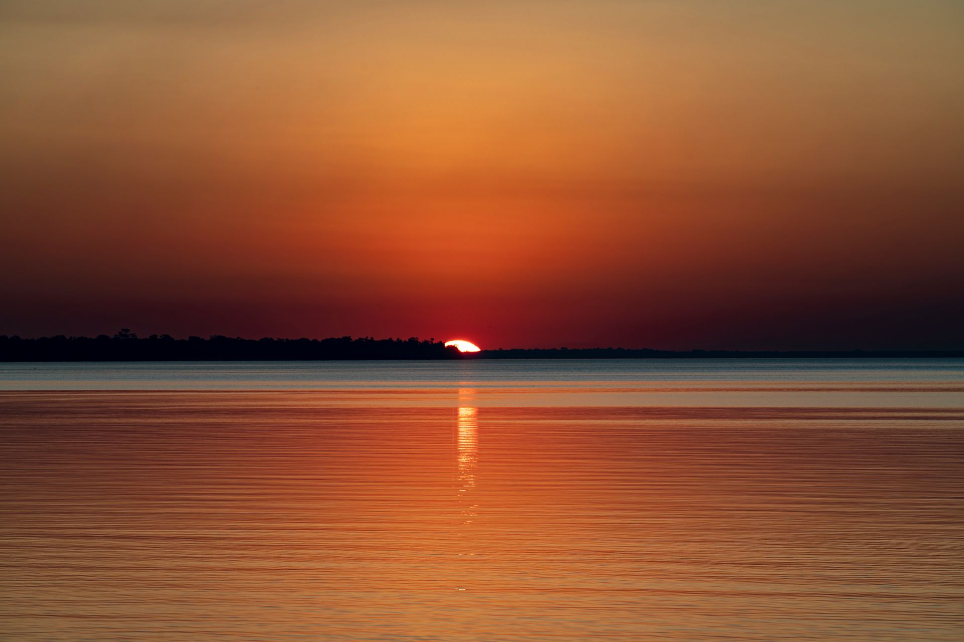 A calm golden sunset over a still horizon, symbolizing the completion and closure of angel number 999