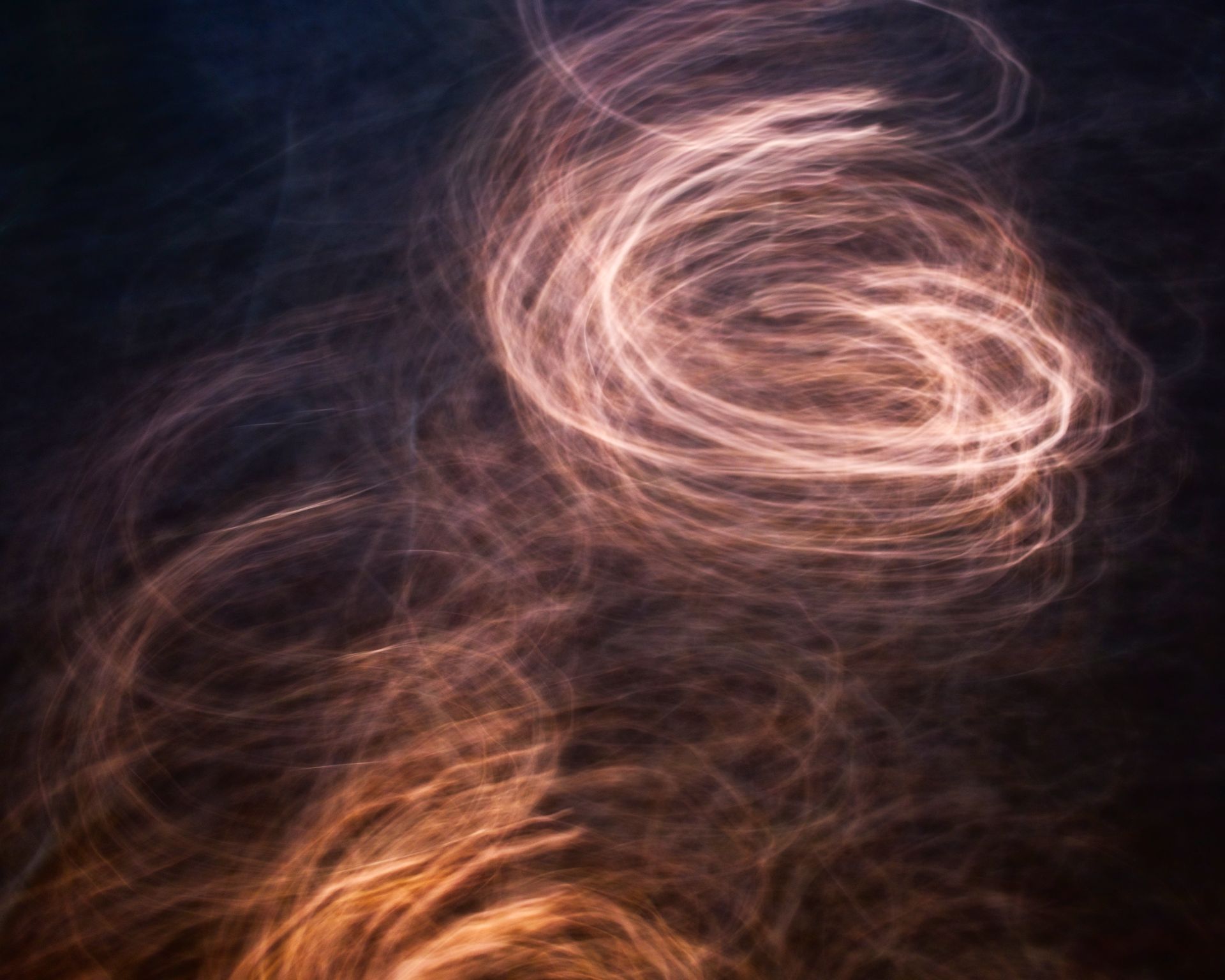 A slow spiral of soft light on a dark background, representing the completing cycle of the number 9 in numerology
