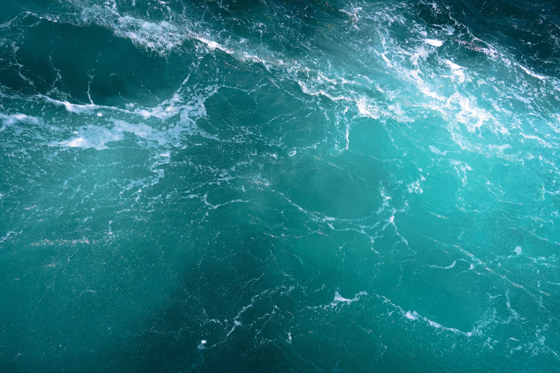 Turquoise ocean waves in clear blue water, reflecting the sea-water origin of the name aquamarine