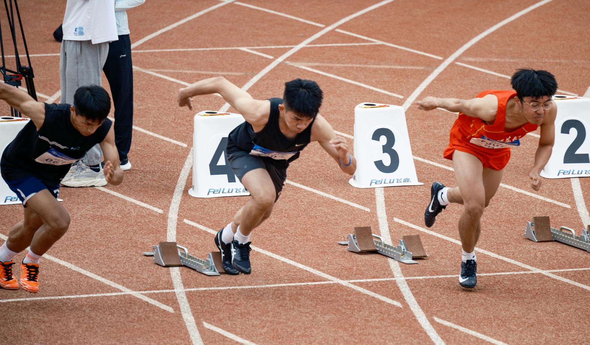 A focused sprinter exploding off the starting line, capturing Aries's drive, energy, and need to go first
