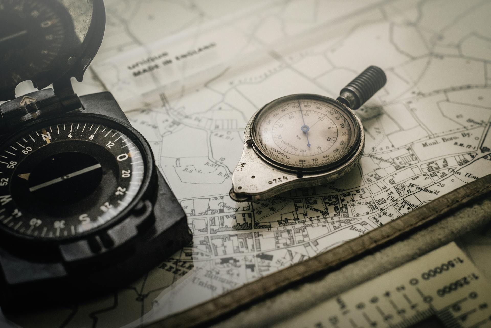 A vintage compass and navigation instrument on an old map