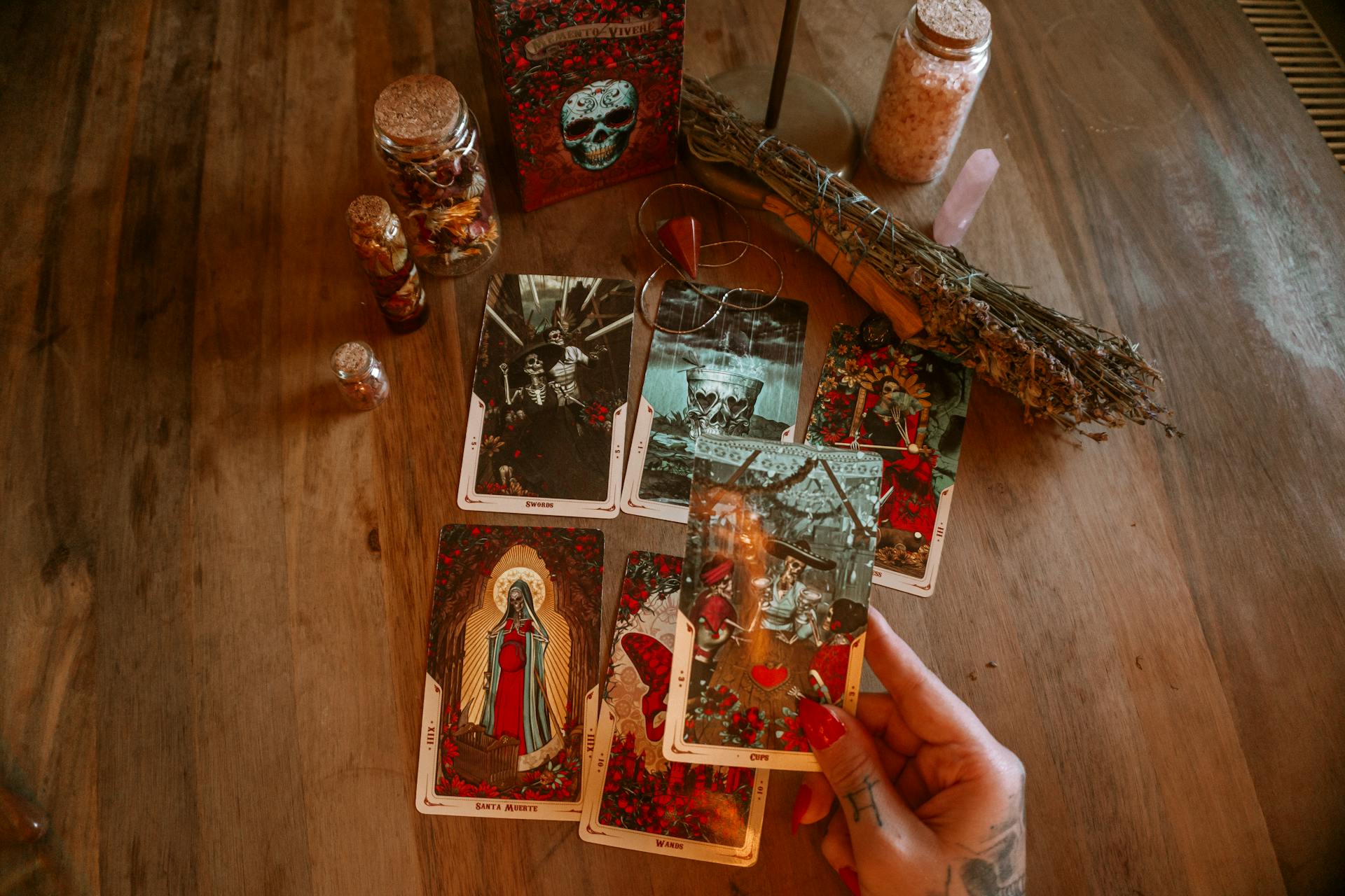 A tarot reader placing cards on a table with candles and amulets creating a mystical atmosphere