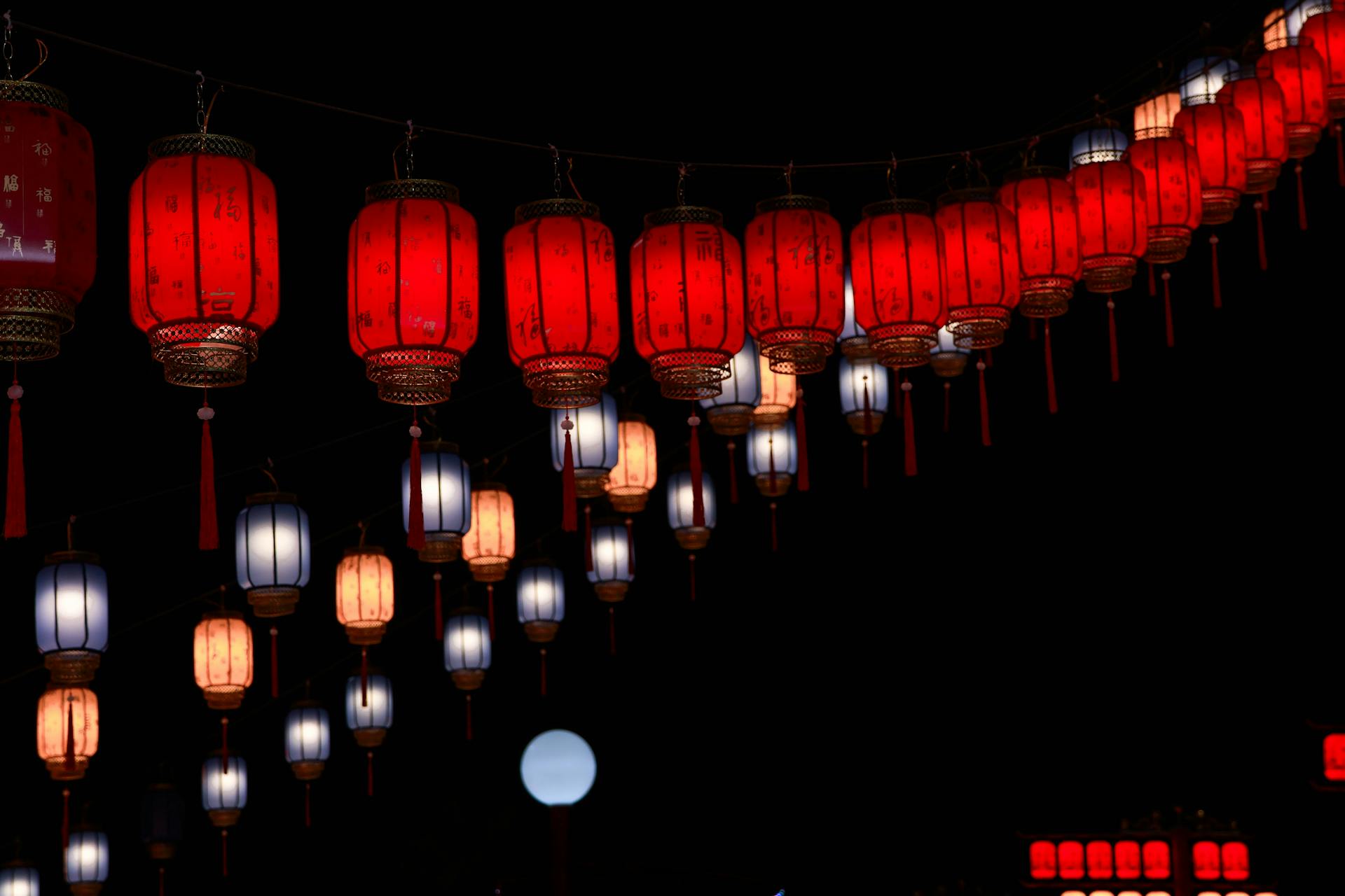 Rows of glowing red Chinese lanterns hanging against a dark night sky, symbolizing the twelve animal signs of Chinese zodiac compatibility