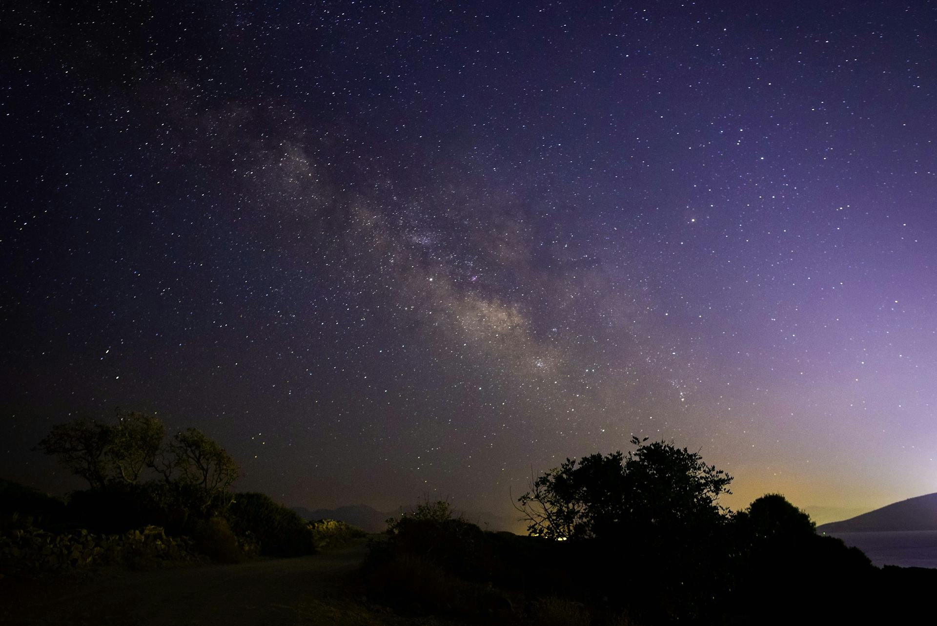 Milky Way stretching across a night sky over ancient Greek landscape
