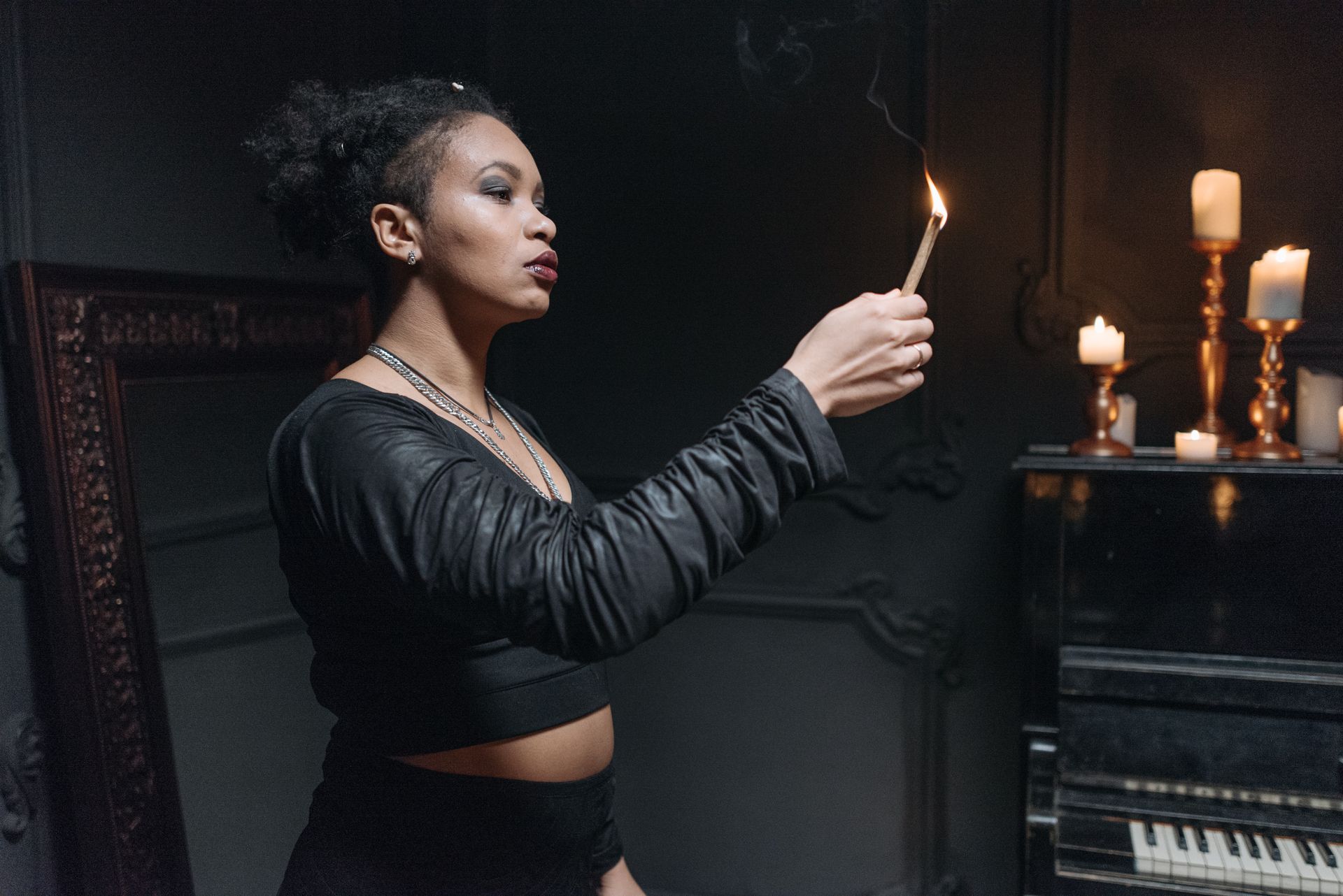 A woman holding a lit candle during a quiet evening ritual, setting the tone for intuitive practice