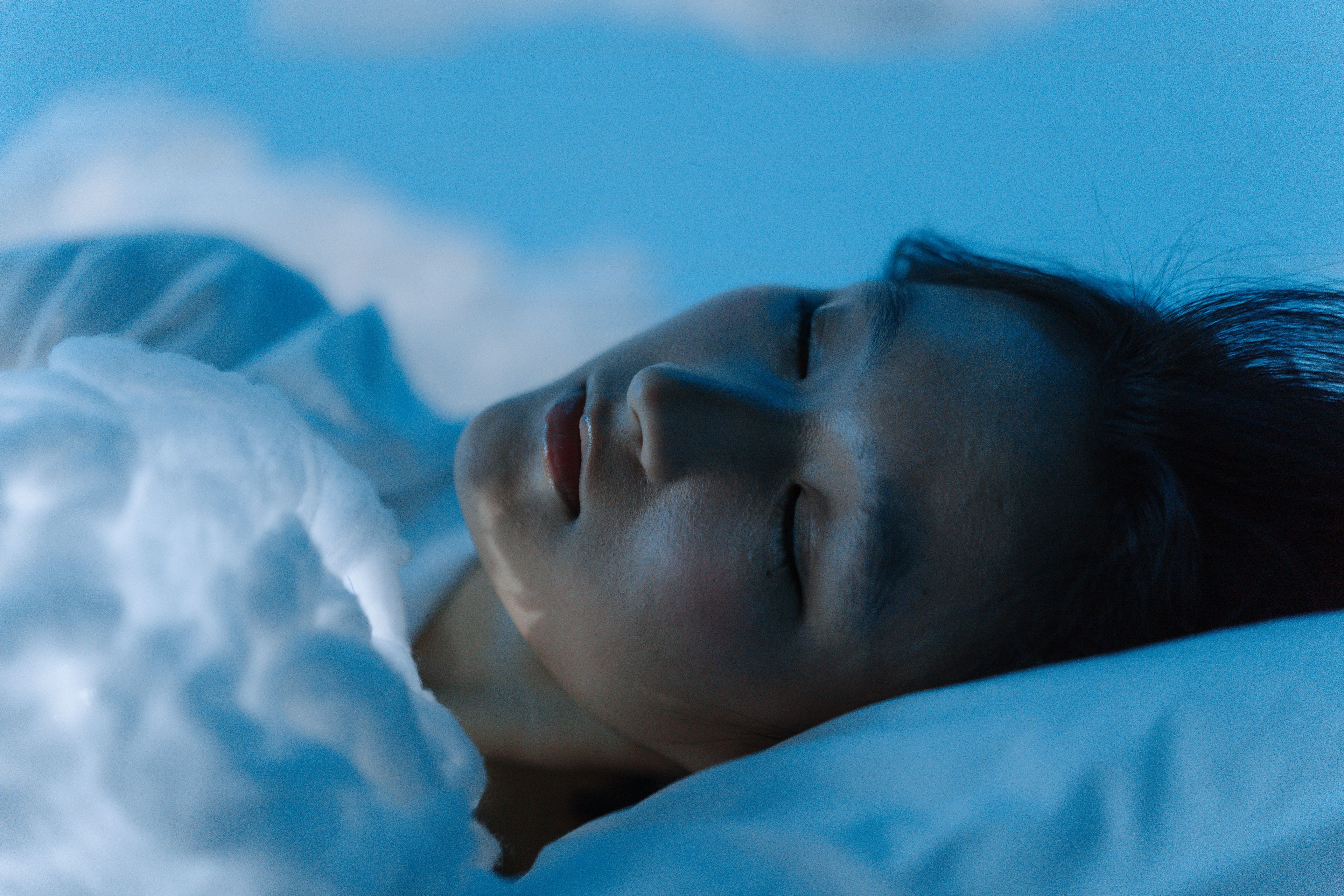 A sleeping figure bathed in soft blue light, representing the inner world explored through dream interpretation
