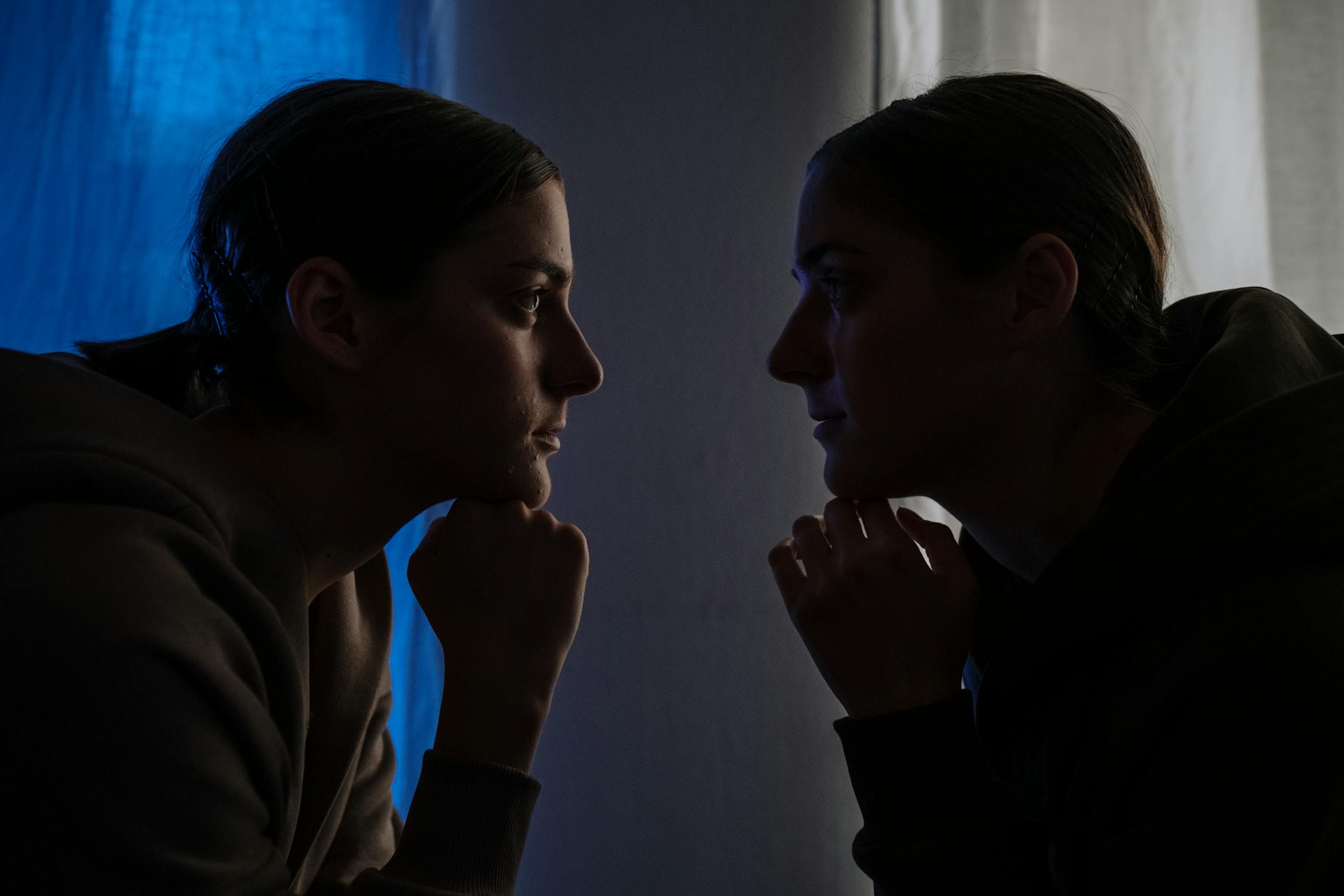 A dramatic image exploring duality and introspection with two figures in deep contemplation evoking the internal conflict of the Five of Swords reversed