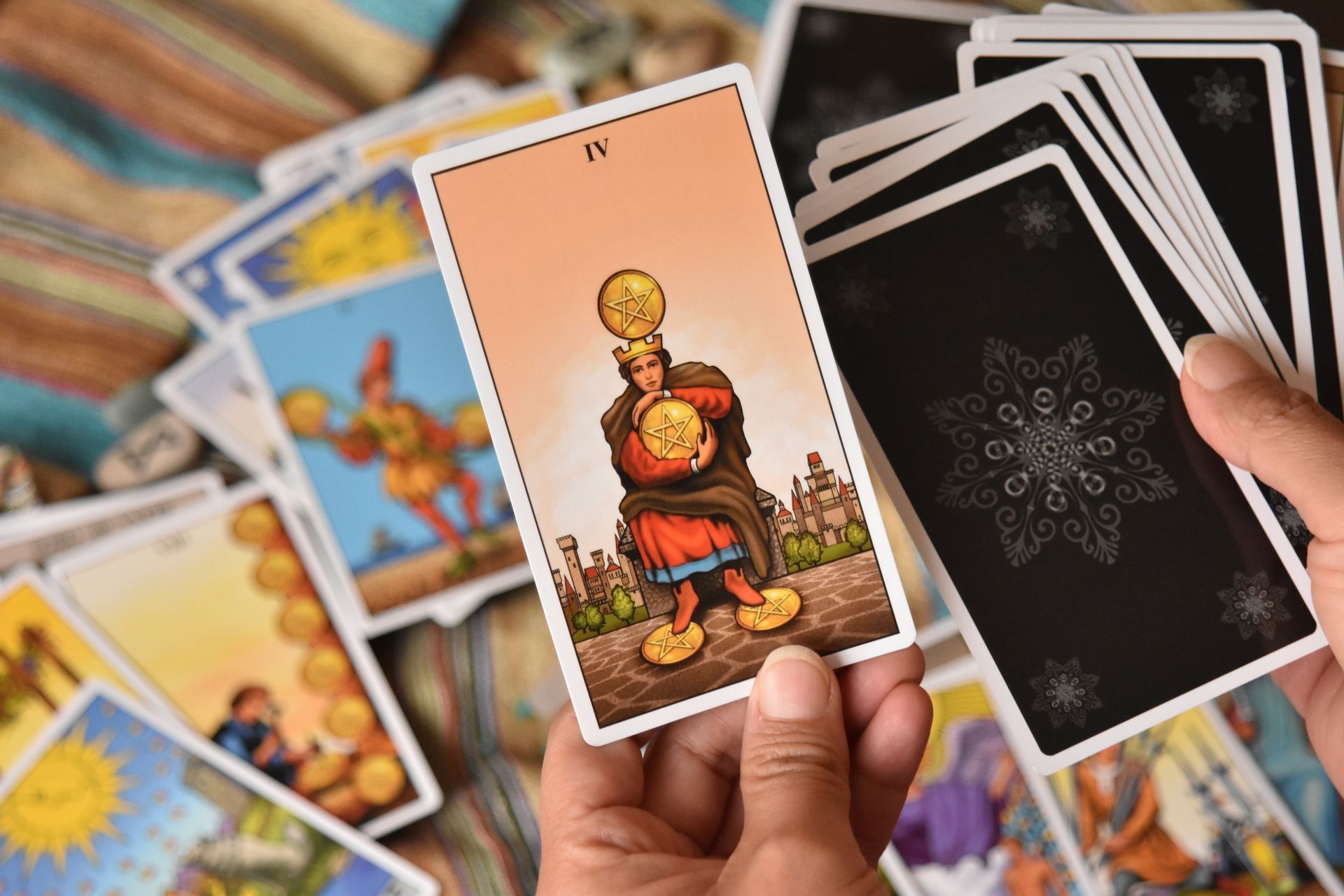 A spread of tarot cards laid across a dark cloth, representing the four suits of the Minor Arcana