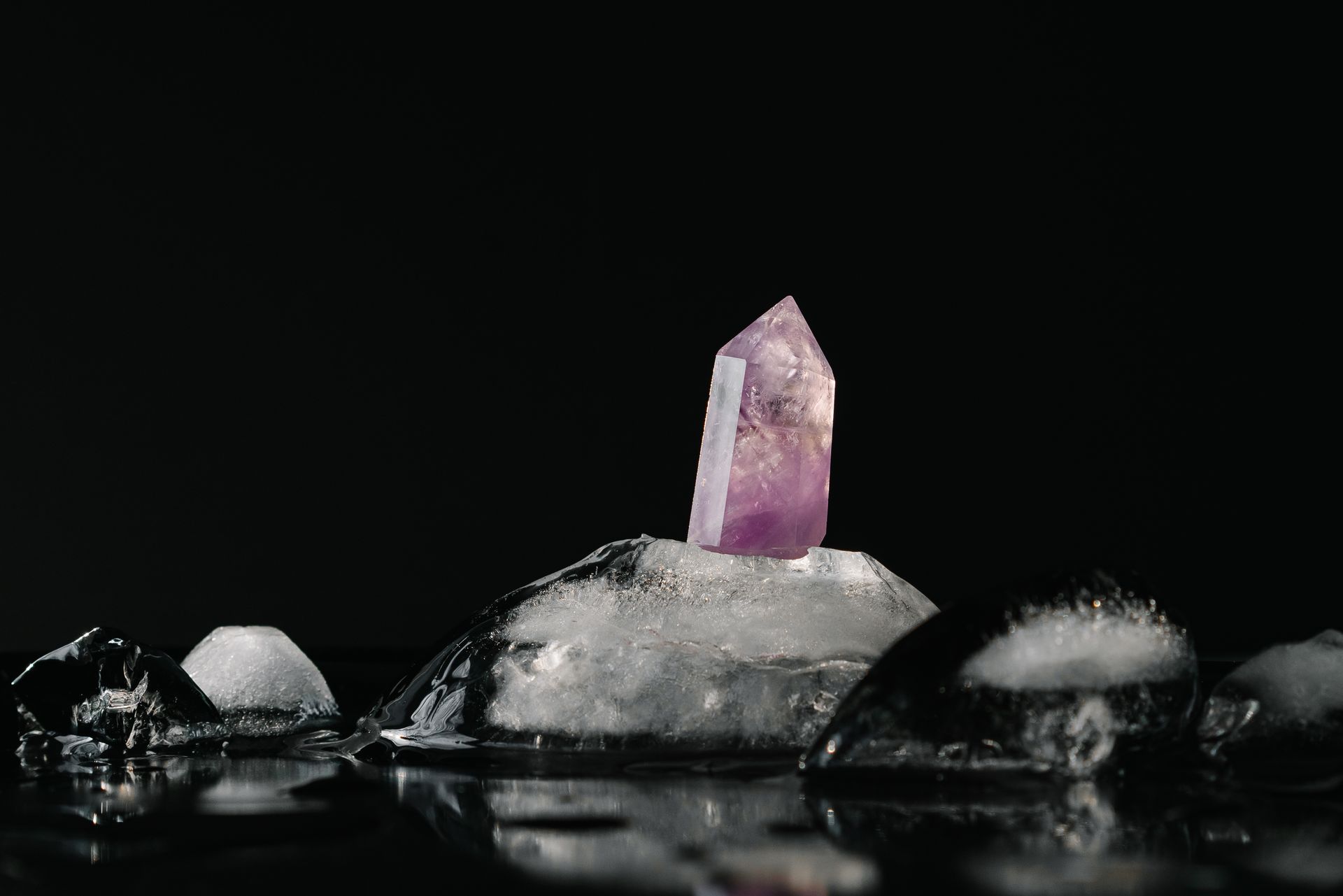 A single raw amethyst cluster glowing purple in warm light, a calming stone popular with beginners