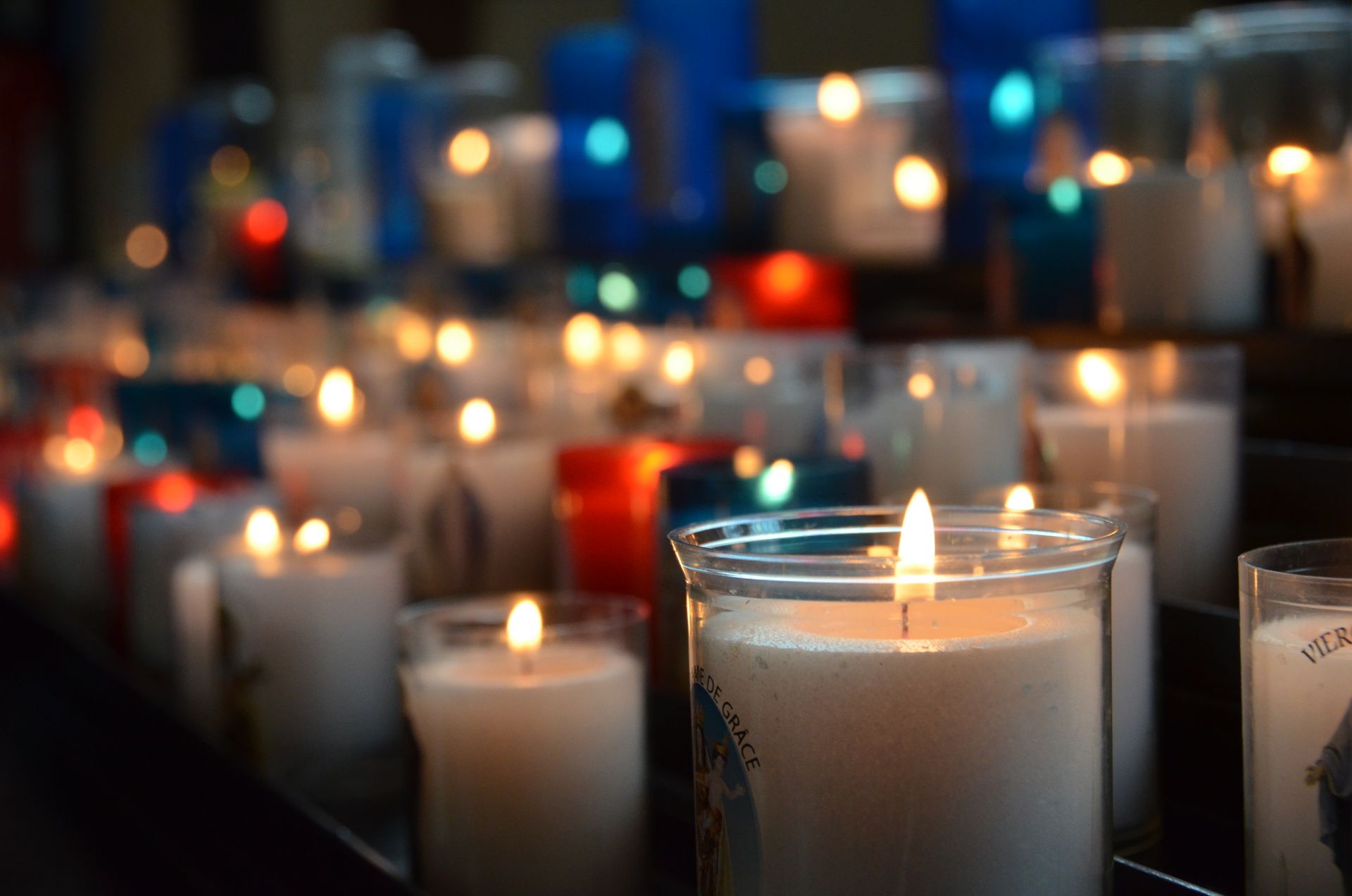 A glowing candle and small altar with crystals set up for a quiet spiritual practice