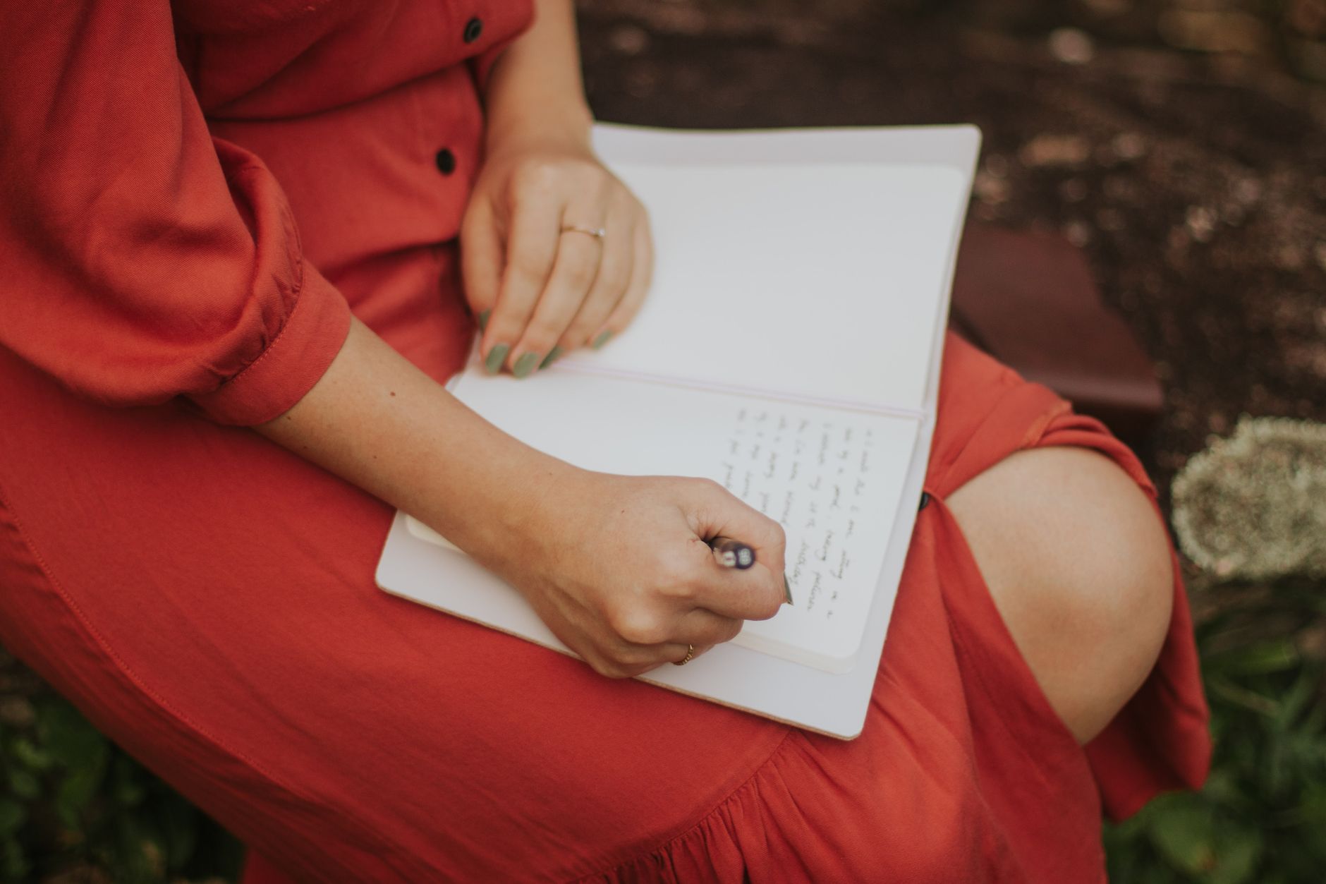 A woman writing in a journal by a window in soft morning light