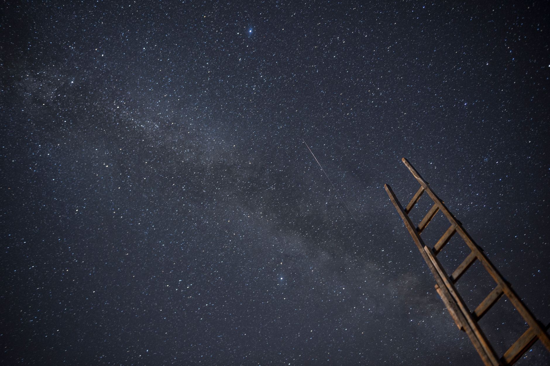 A vivid starry night sky over a dark horizon, symbolizing possibility and dreams
