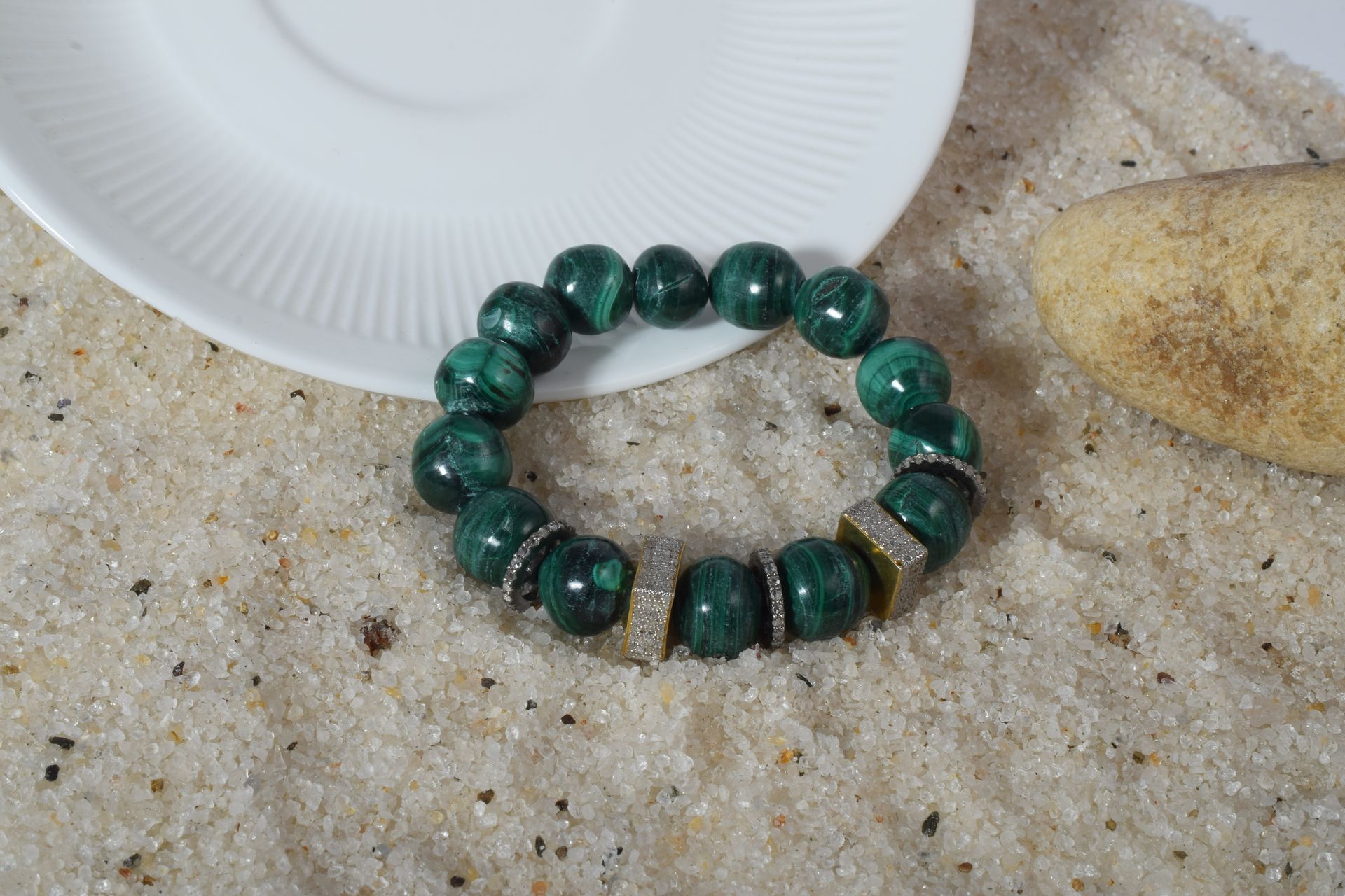 Green malachite bead bracelet resting on a soft surface, representing how to use and wear malachite