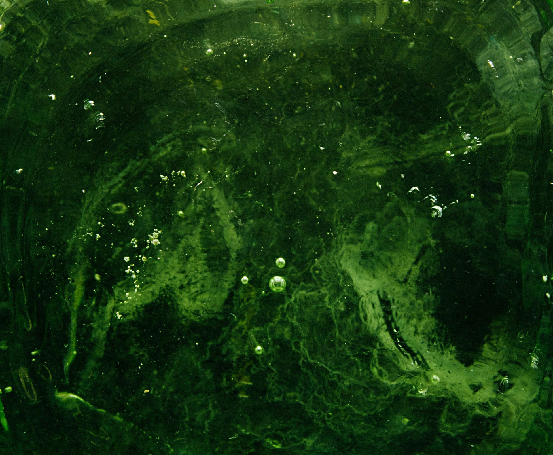 Swirling green glass with bubbles, evoking the molten origin of moldavite tektite