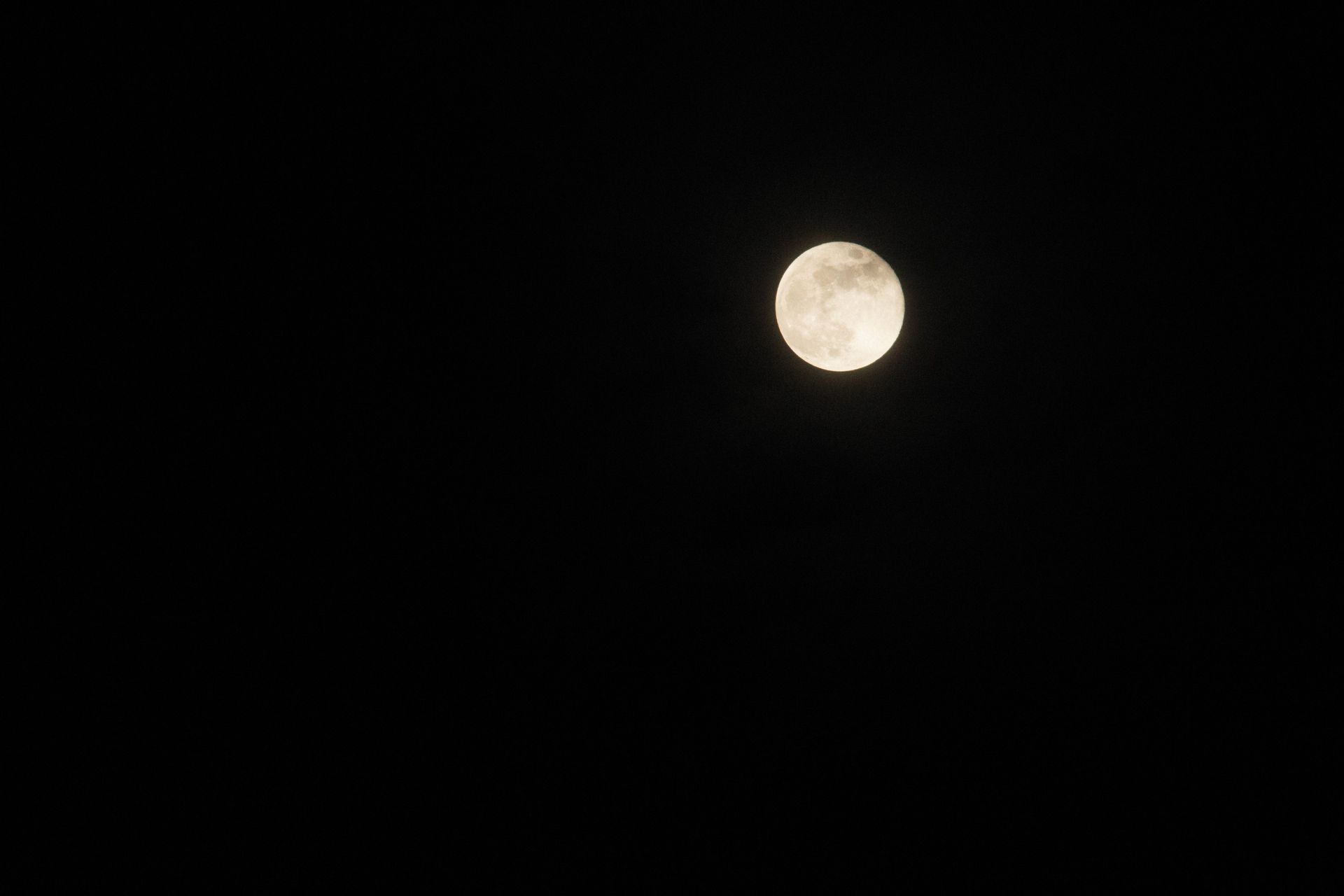 A bright full moon over a dark night landscape, the peak phase for charging full moon water