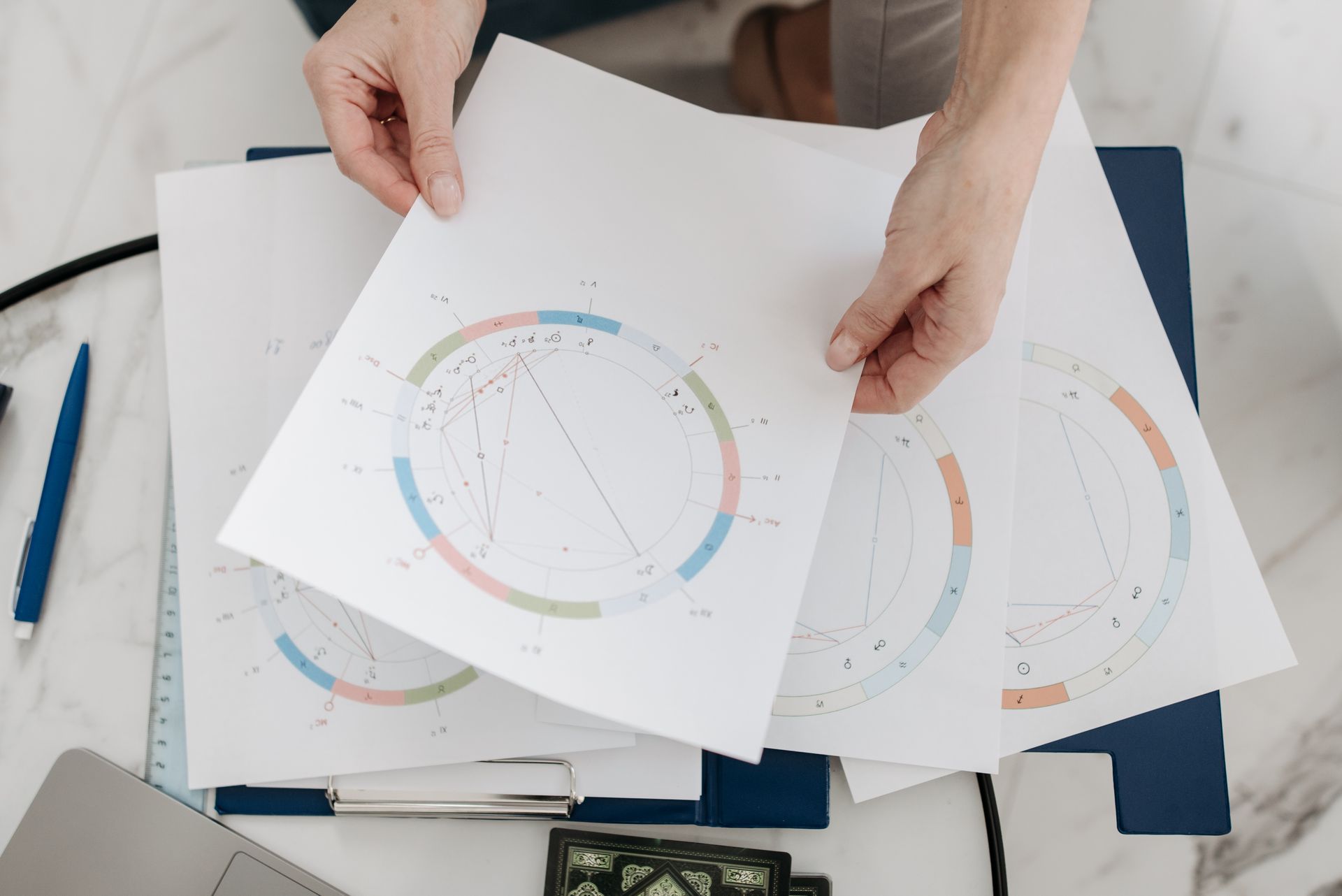 Hands holding astrological charts side by side, illustrating two planets in mutual reception trading signs