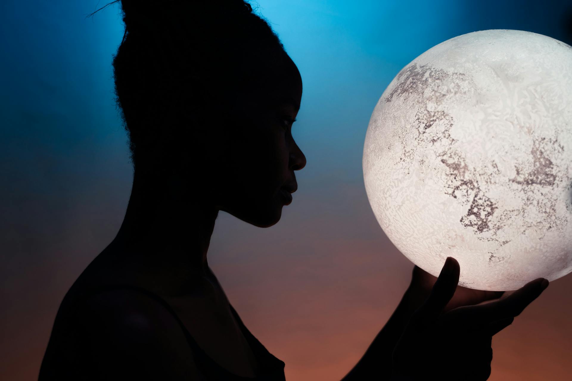 A figure standing in soft moonlight gazing upward representing the way the natal lunar phase shapes how a person connects with others