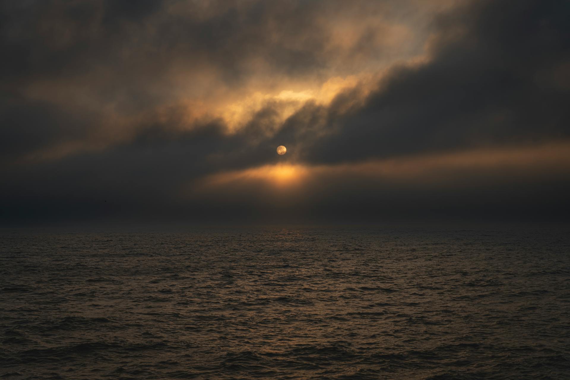 Sunrise over calm ocean waters representing the new dawn of a 14 year Neptune transit through Aries