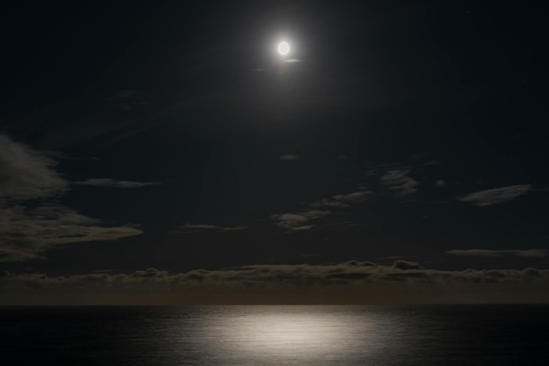 A glowing full moon over a calm ocean at night, reflecting the deep emotional currents and inner tides of the Pisces heart