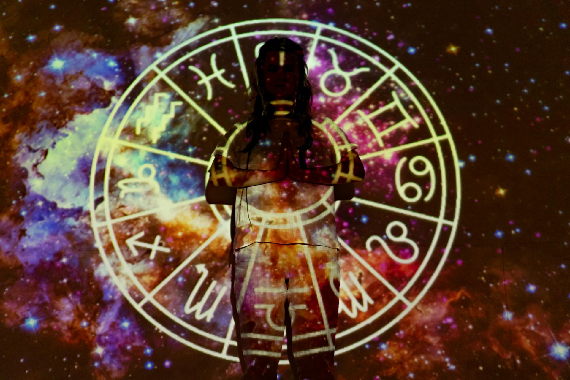 Silhouette of a person with celestial astrology symbols against a cosmic background representing the rising sign influence