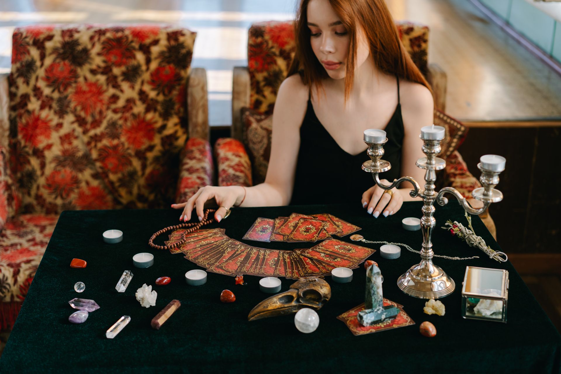 Deep red and earthy crystals arranged for a grounding meditation, the kind of stones traditionally used for root chakra healing