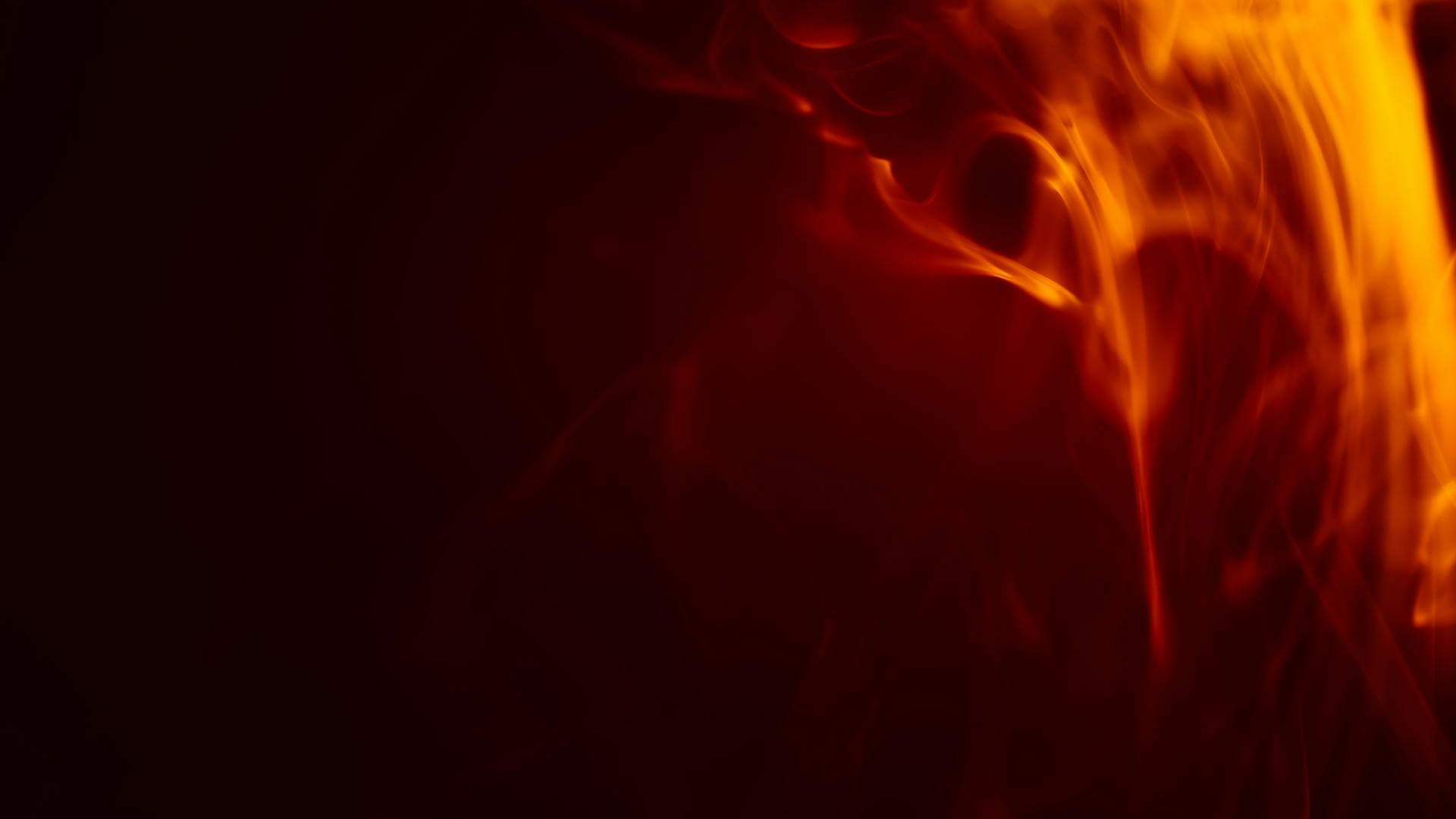 Vivid orange and red flames against a dark background representing the channeled fire energy of Saturn in Aries