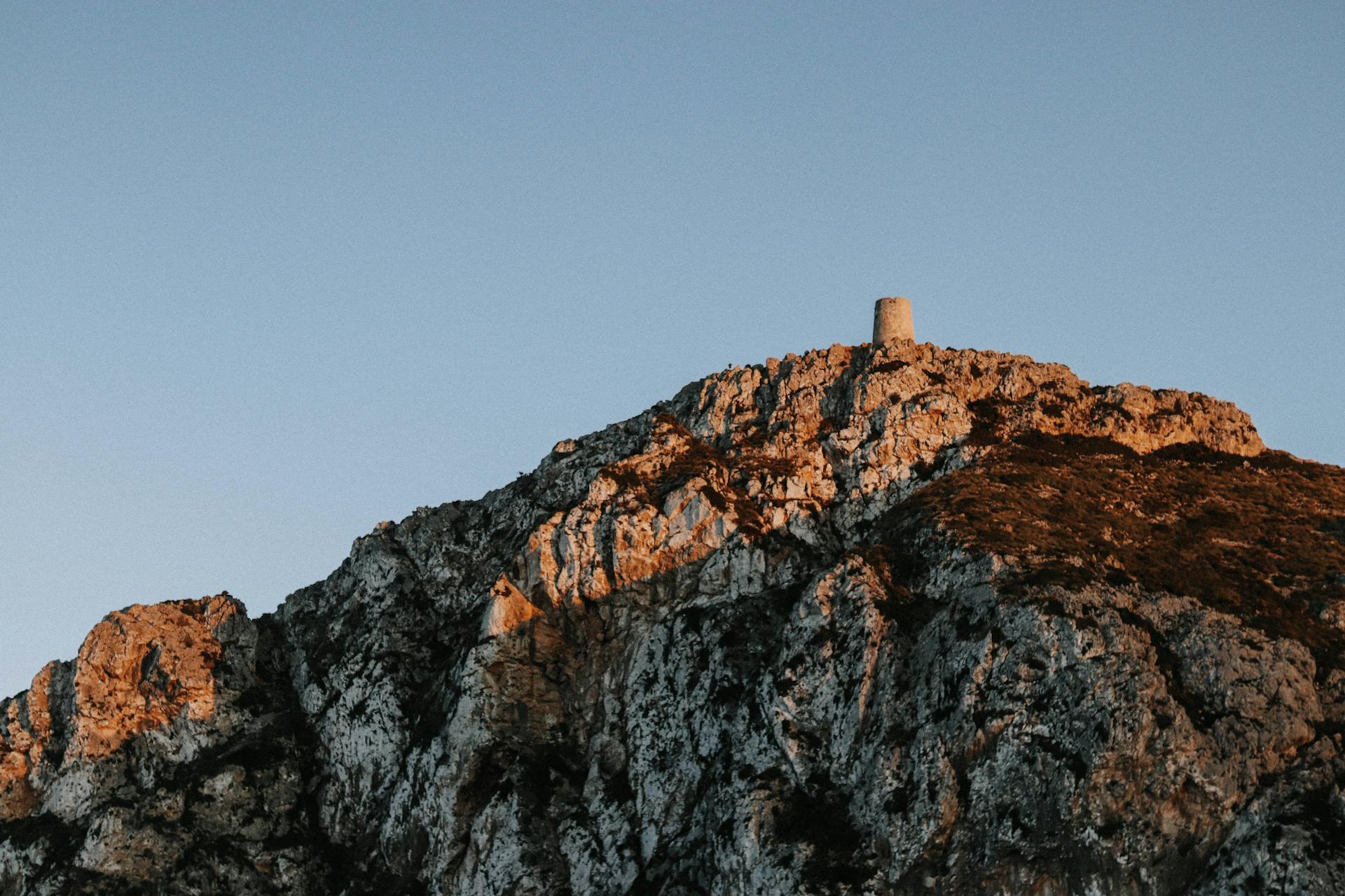 A striking view of a rocky mountain with a lone tower at dusk capturing the serene beauty of endurance and structure
