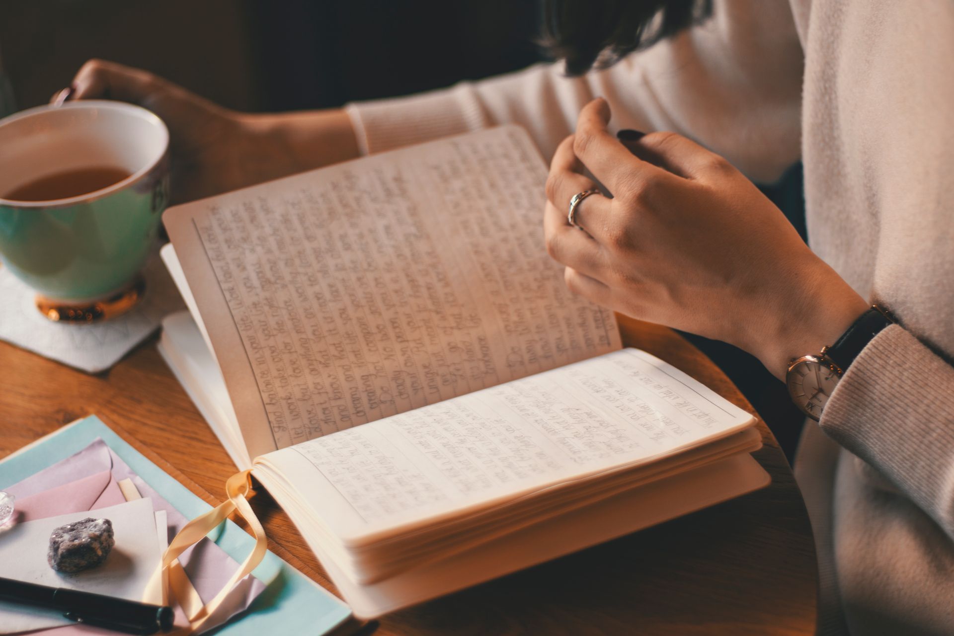 A woman writing in a journal with a cup of coffee, relaxed and unhurried