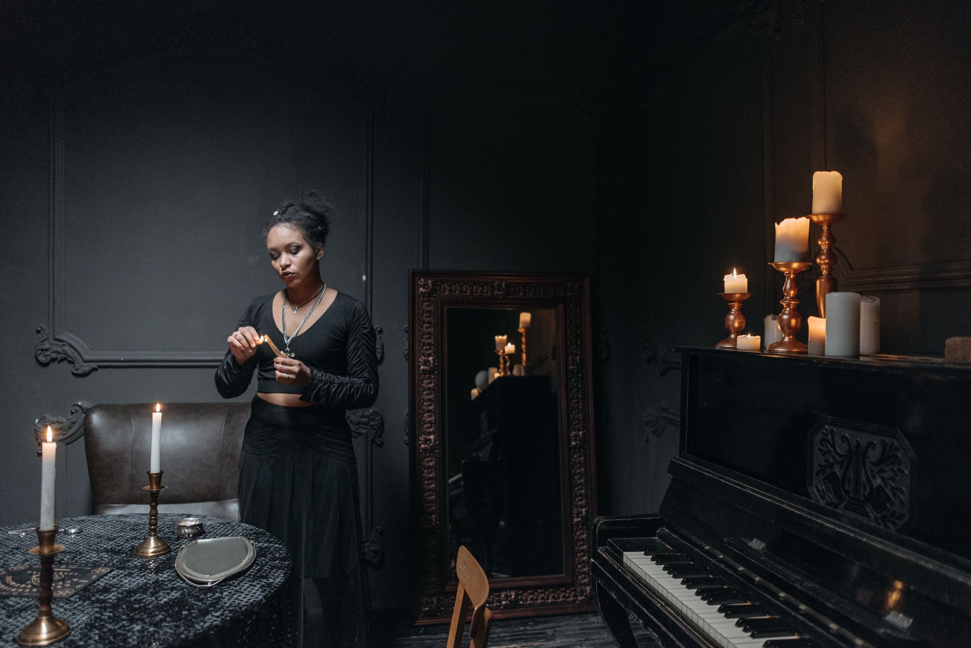 A dark mirror surface lit by candlelight, the kind of low reflection used in black mirror scrying