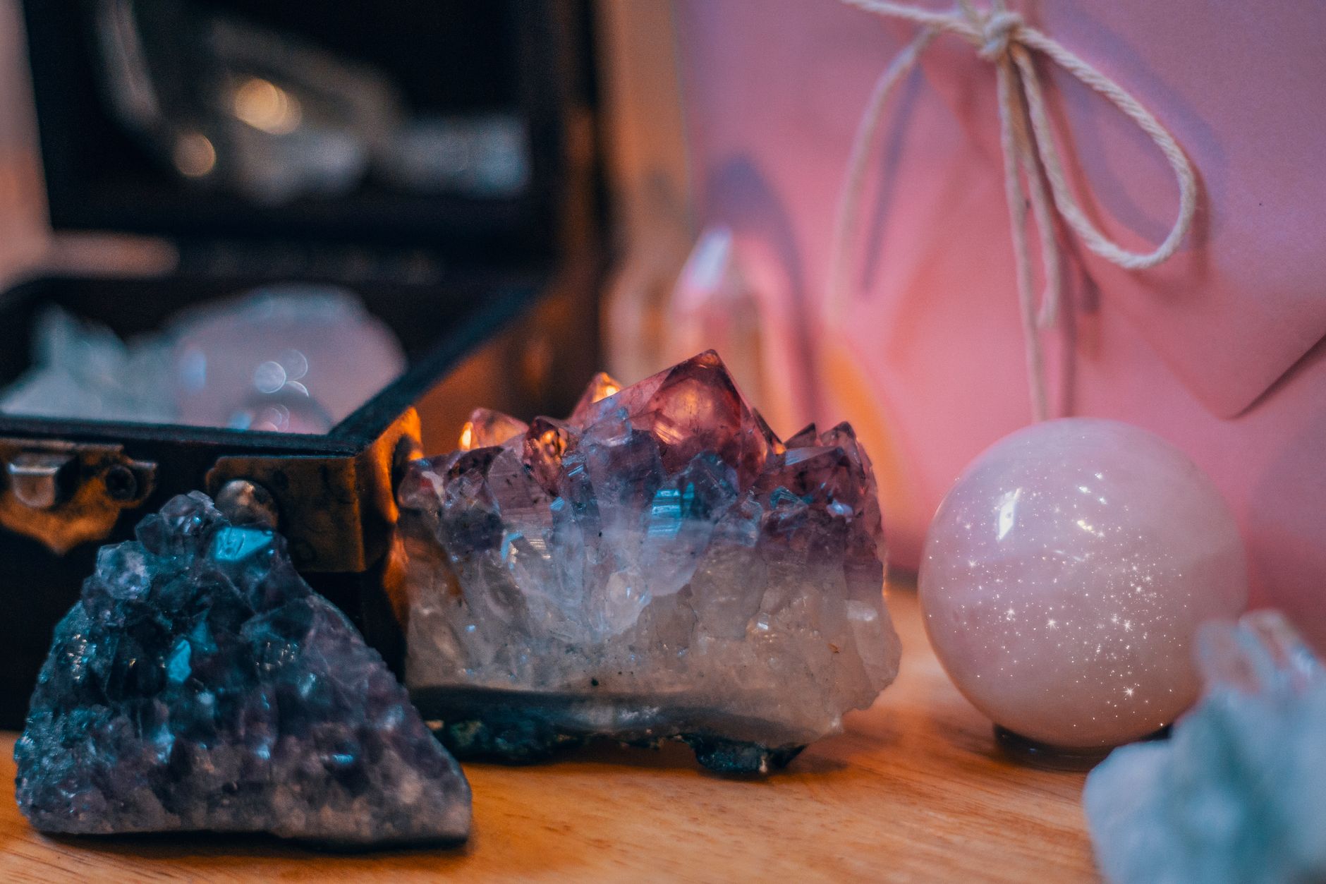 A spread of healing crystals in chakra colors arranged on a soft surface