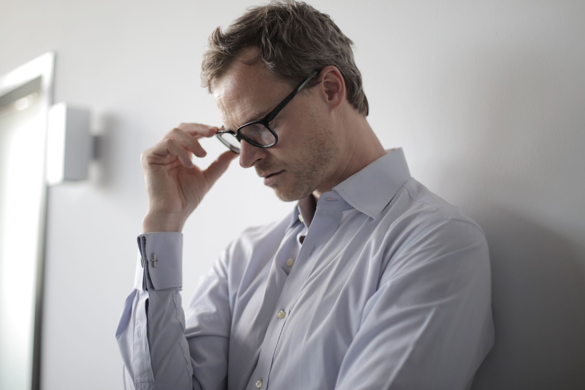 A person resting their head in their hands by a window, reflecting on where energy feels stuck