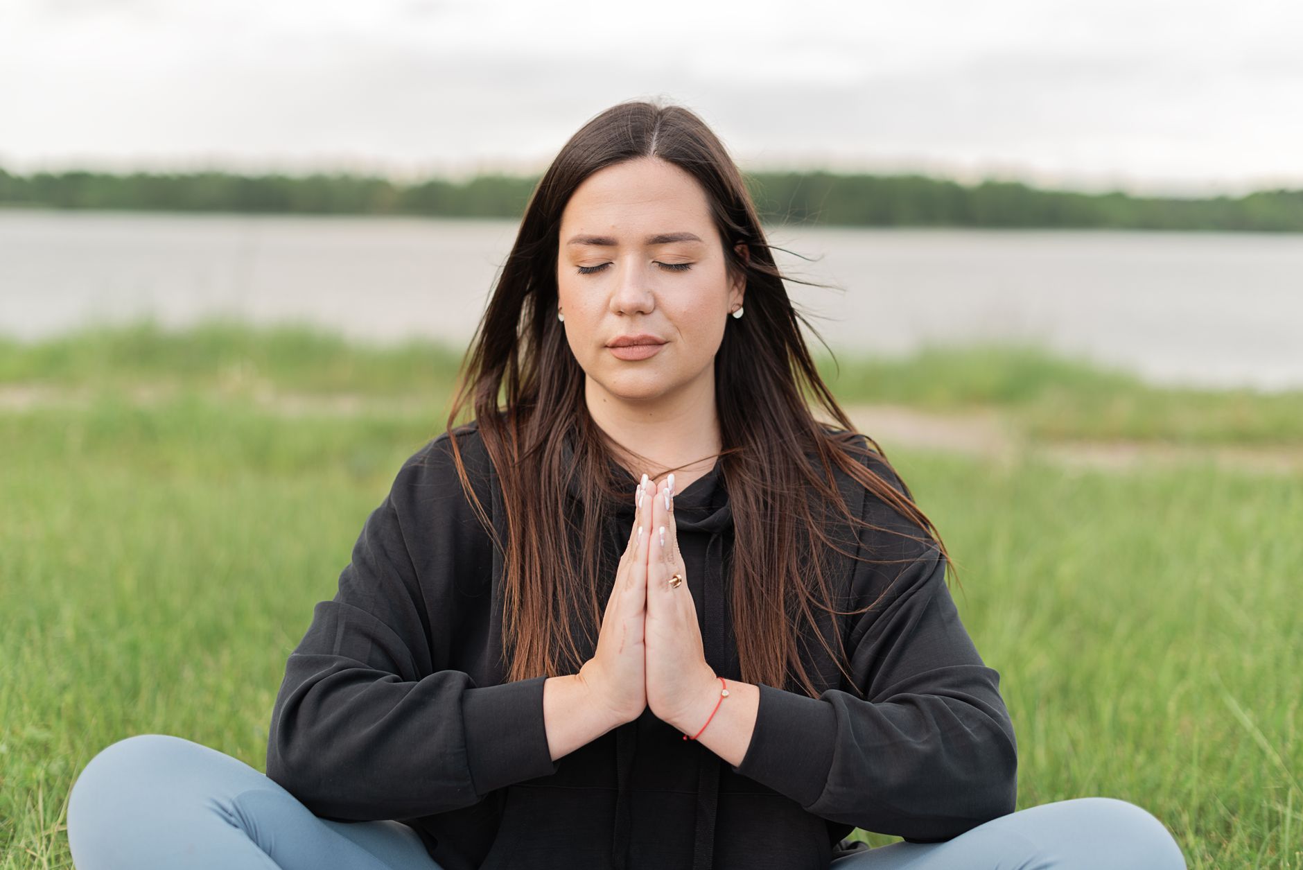A person meditating in soft blue light, symbolizing the calm, clear energy of an open Vishuddha throat chakra
