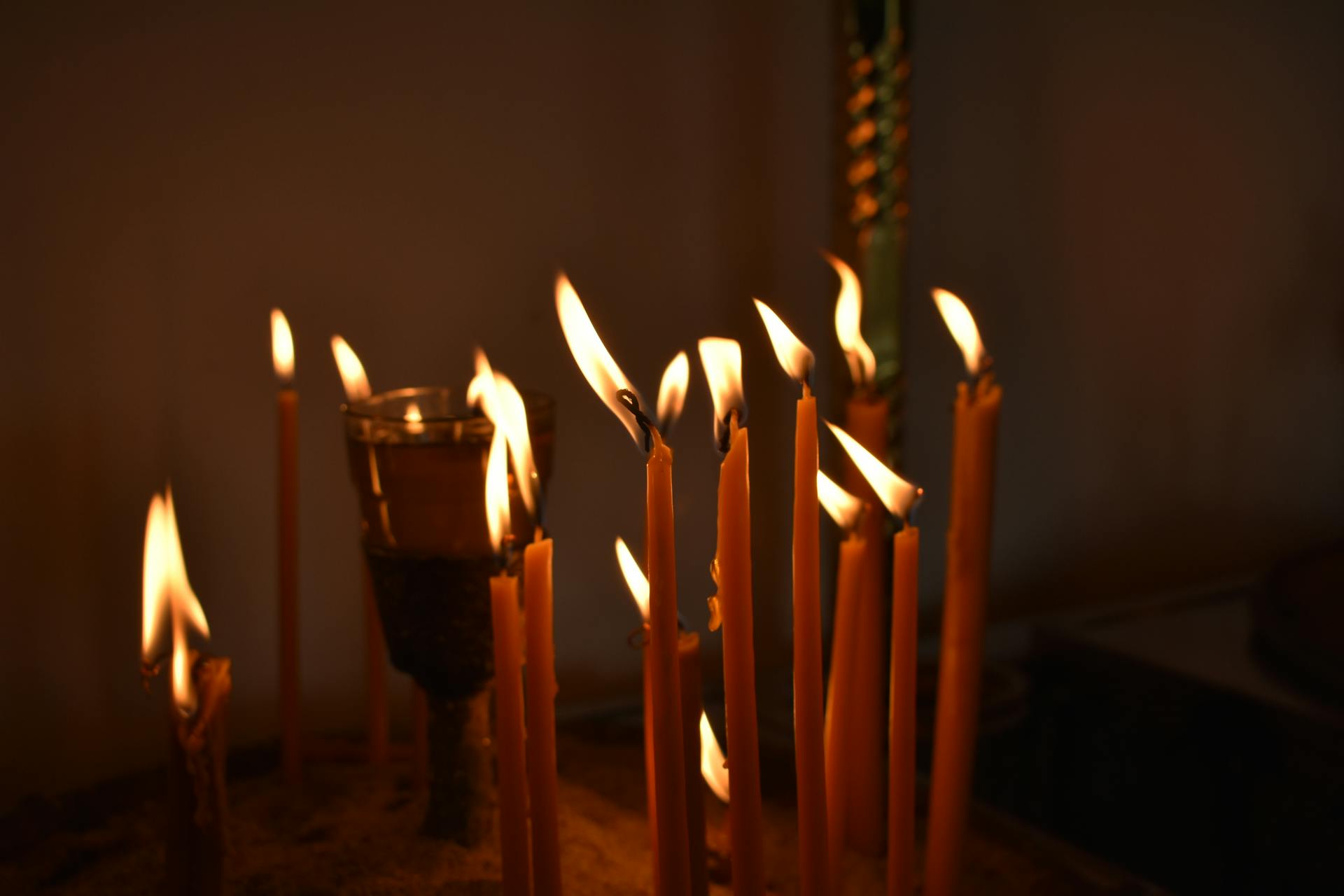 A person sitting in darkness illuminated by a single beam of light symbolizing the process of bringing hidden aspects of self into awareness