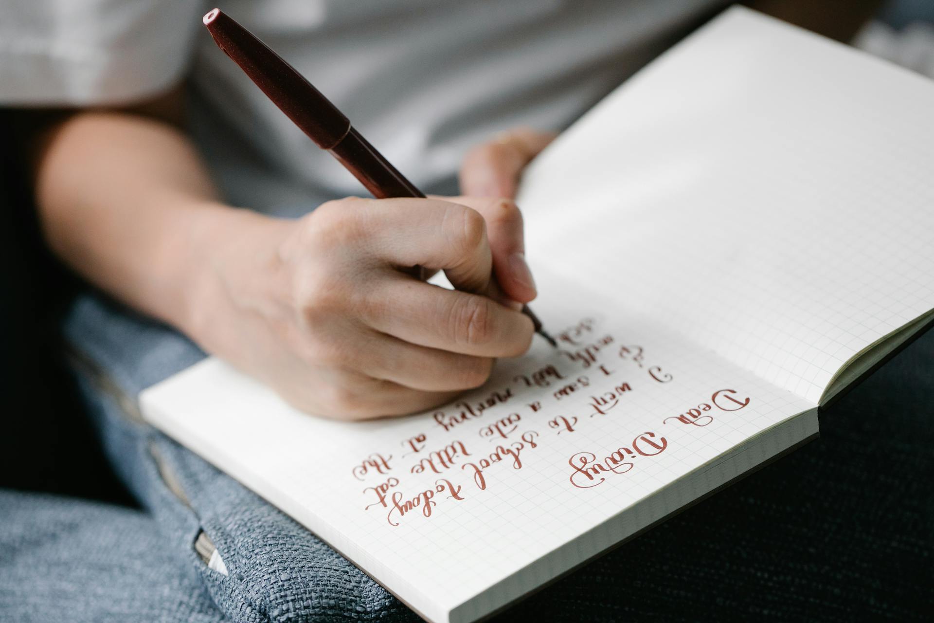 A person writing in a journal by soft lamp light in a contemplative setting representing self-reflection and shadow work practice