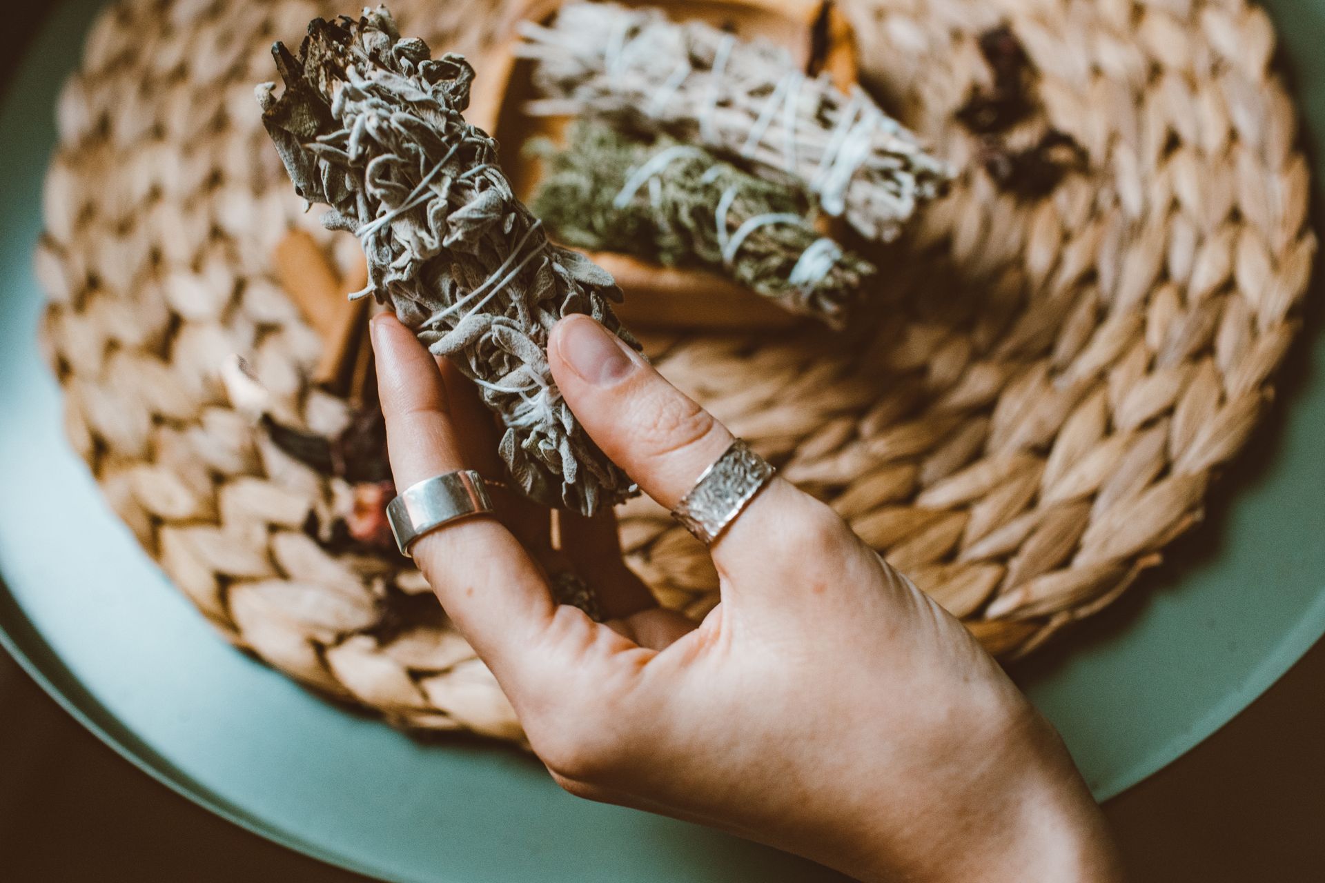 A tied bundle of dried garden herbs resting on a wooden surface, ready for smoke cleansing