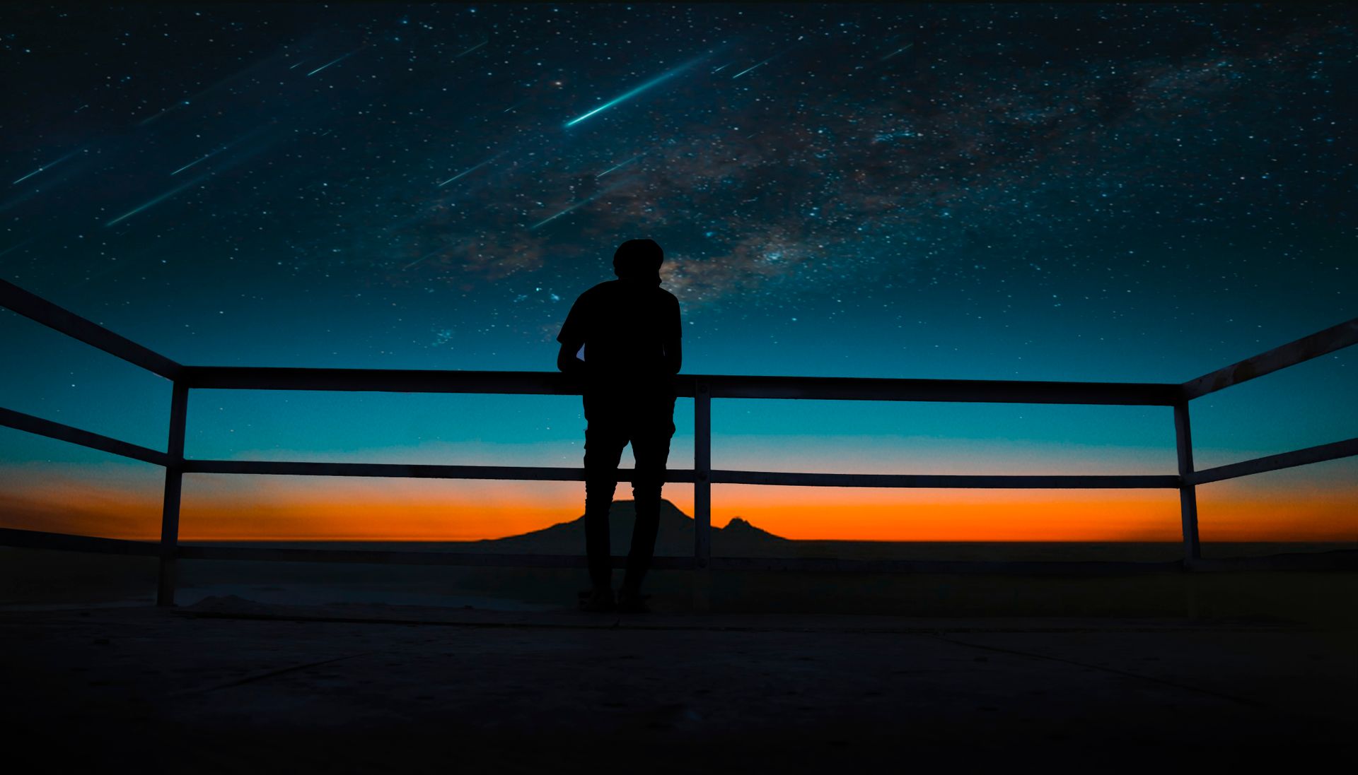 A lone silhouette beneath a deep, vivid night sky, representing the dark night of the soul