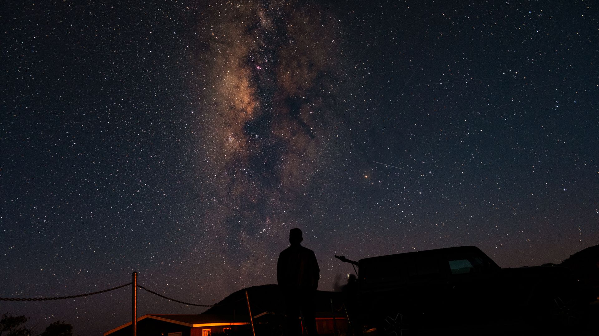 A person standing beneath a vast star-filled sky, representing the expanded awareness of a spiritual awakening