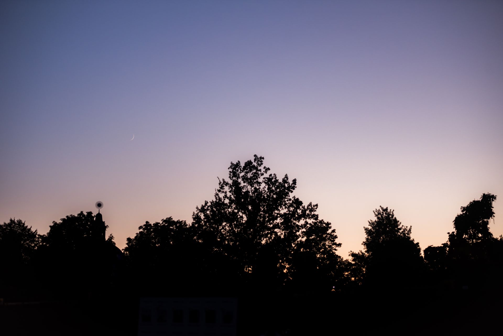 Sun and moon visible together in a soft daytime sky, symbolizing the blend of identity and emotion in a sun and moon sign combination