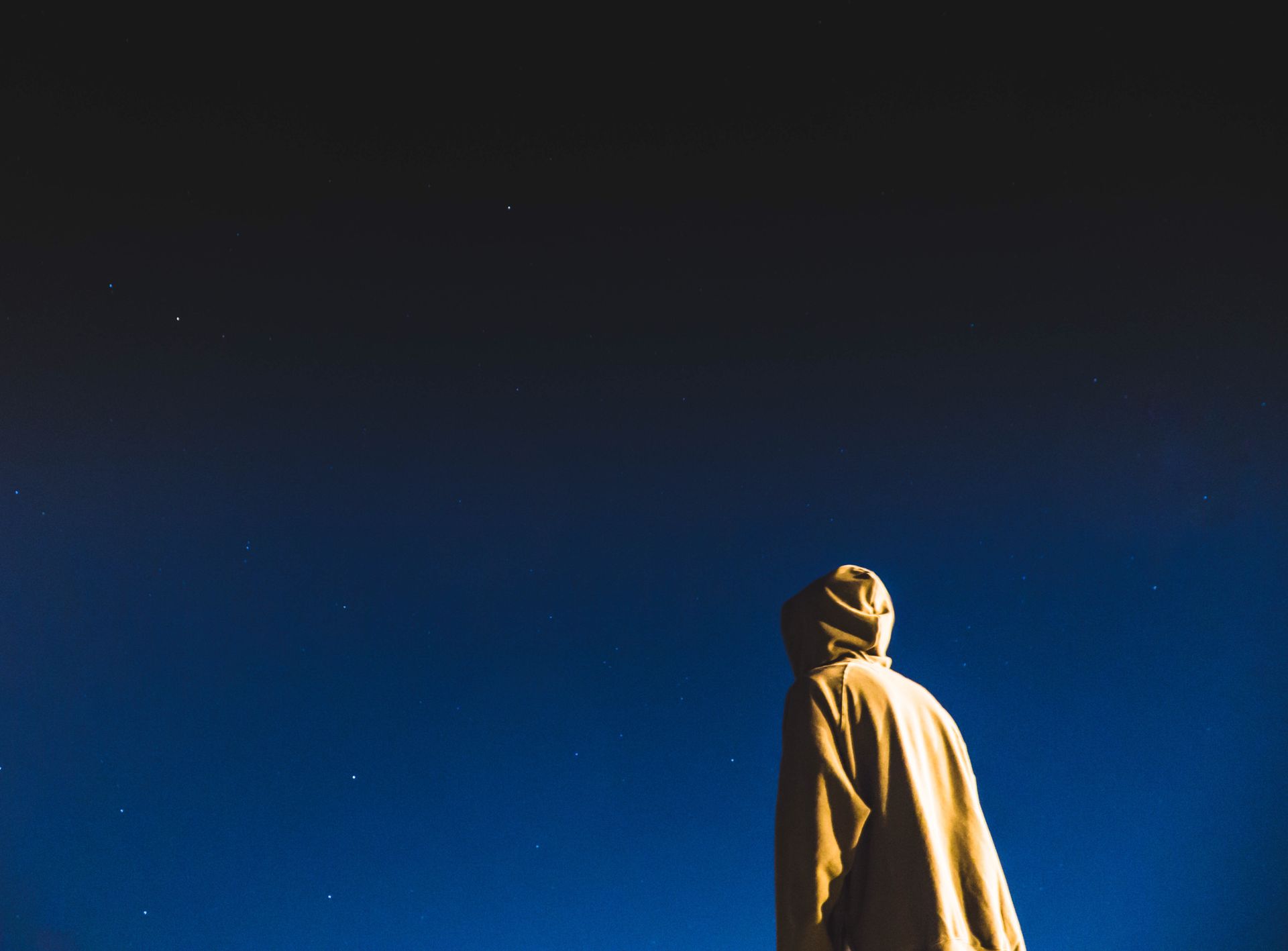 Person standing in silhouette beneath a sky full of stars, representing the inner emotional self of the moon sign