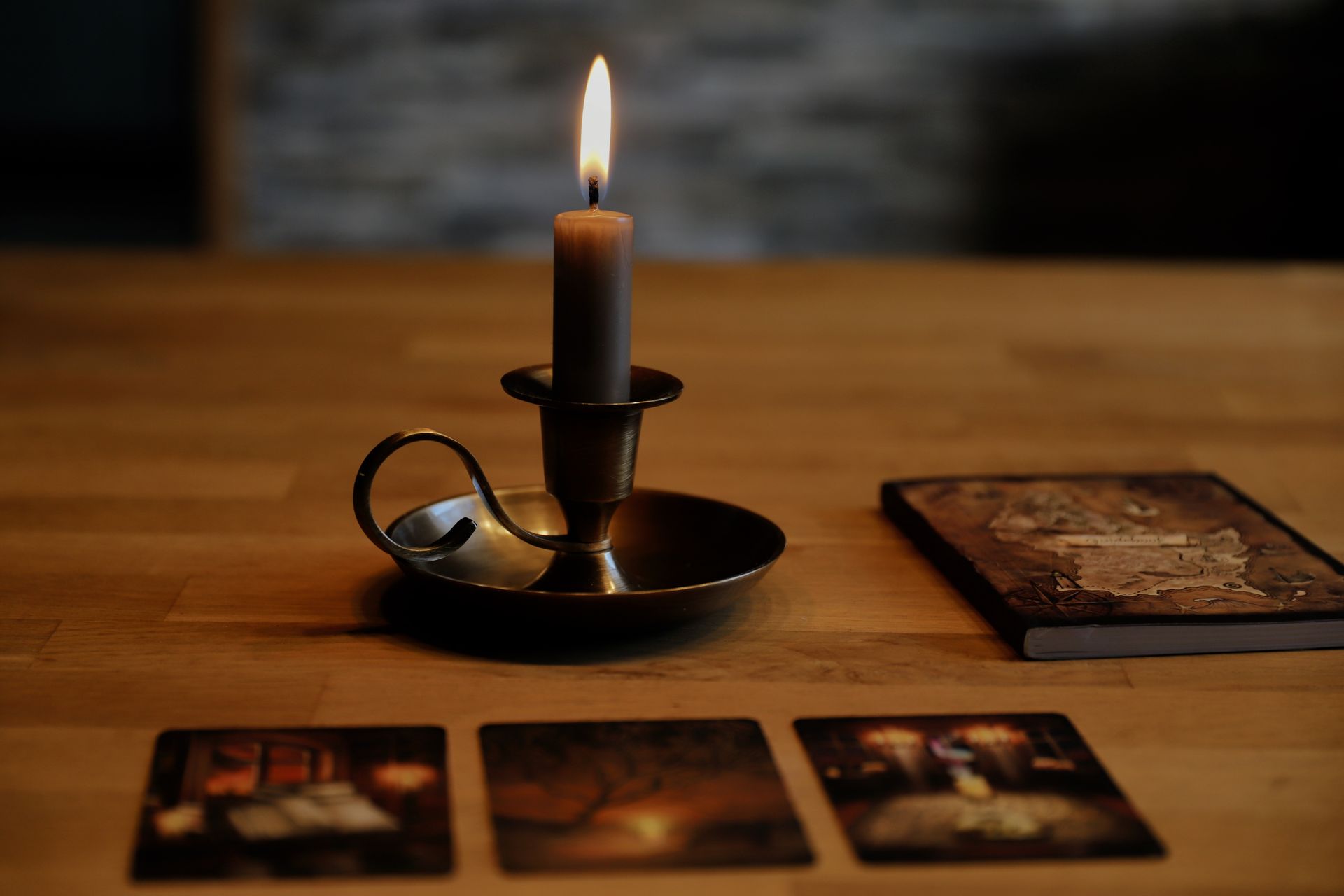Tarot cards beside a glowing candle, creating an intimate reading atmosphere